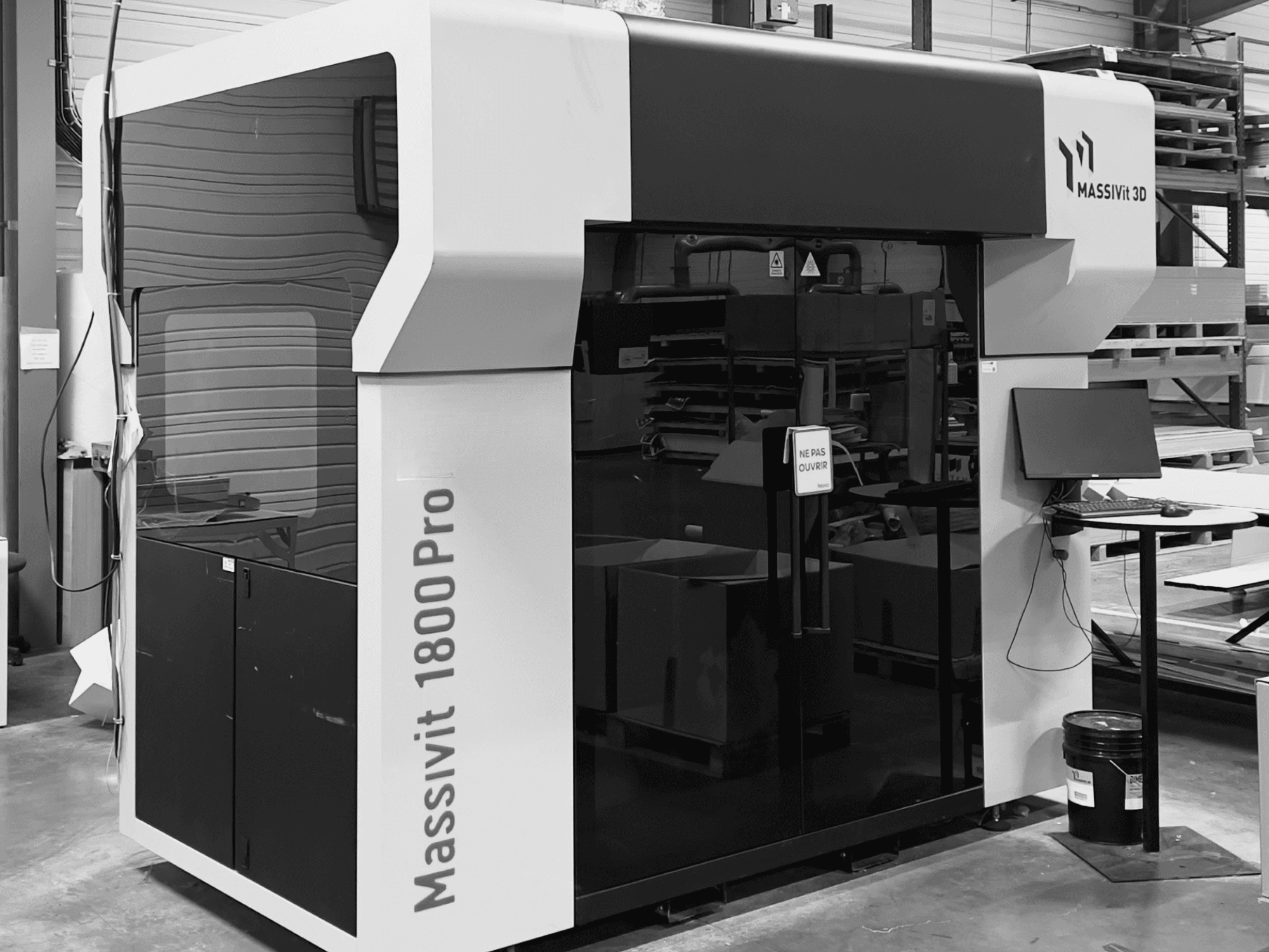 3D-принтер для печати из пластика MASSIVIT 1800 PRO в мастерской, вид спереди; на снимке видны компьютерная рабочая станция и панель управления.
