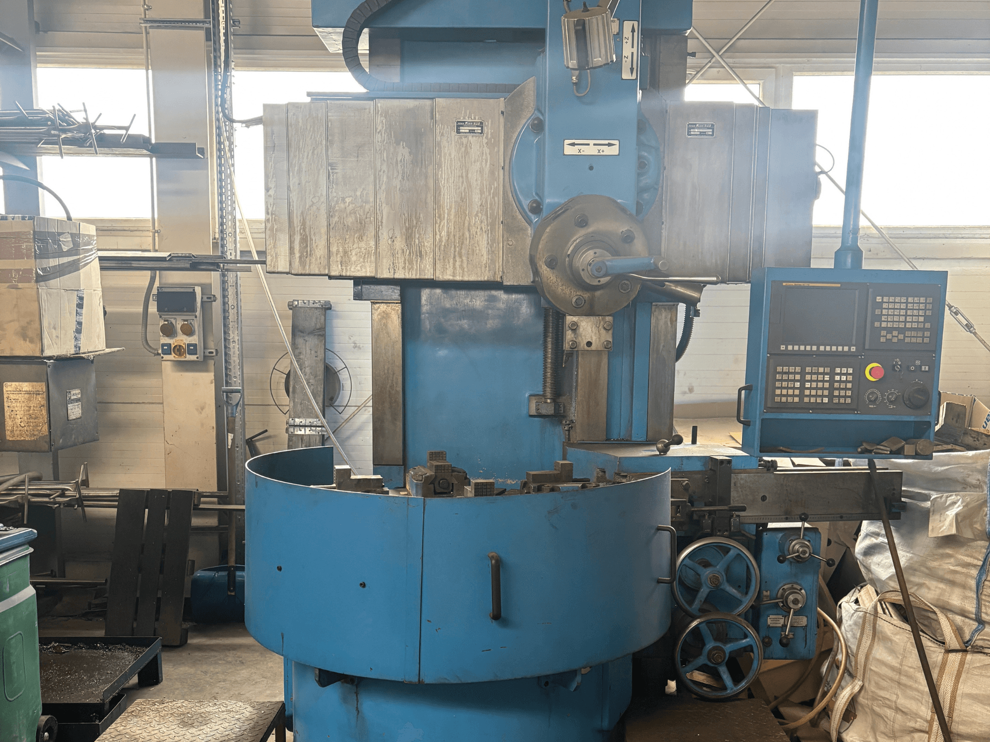 Промышленный фрезерный станок неизвестного бренда, вид спереди, с синей внешней стороной и цифровой панелью управления.