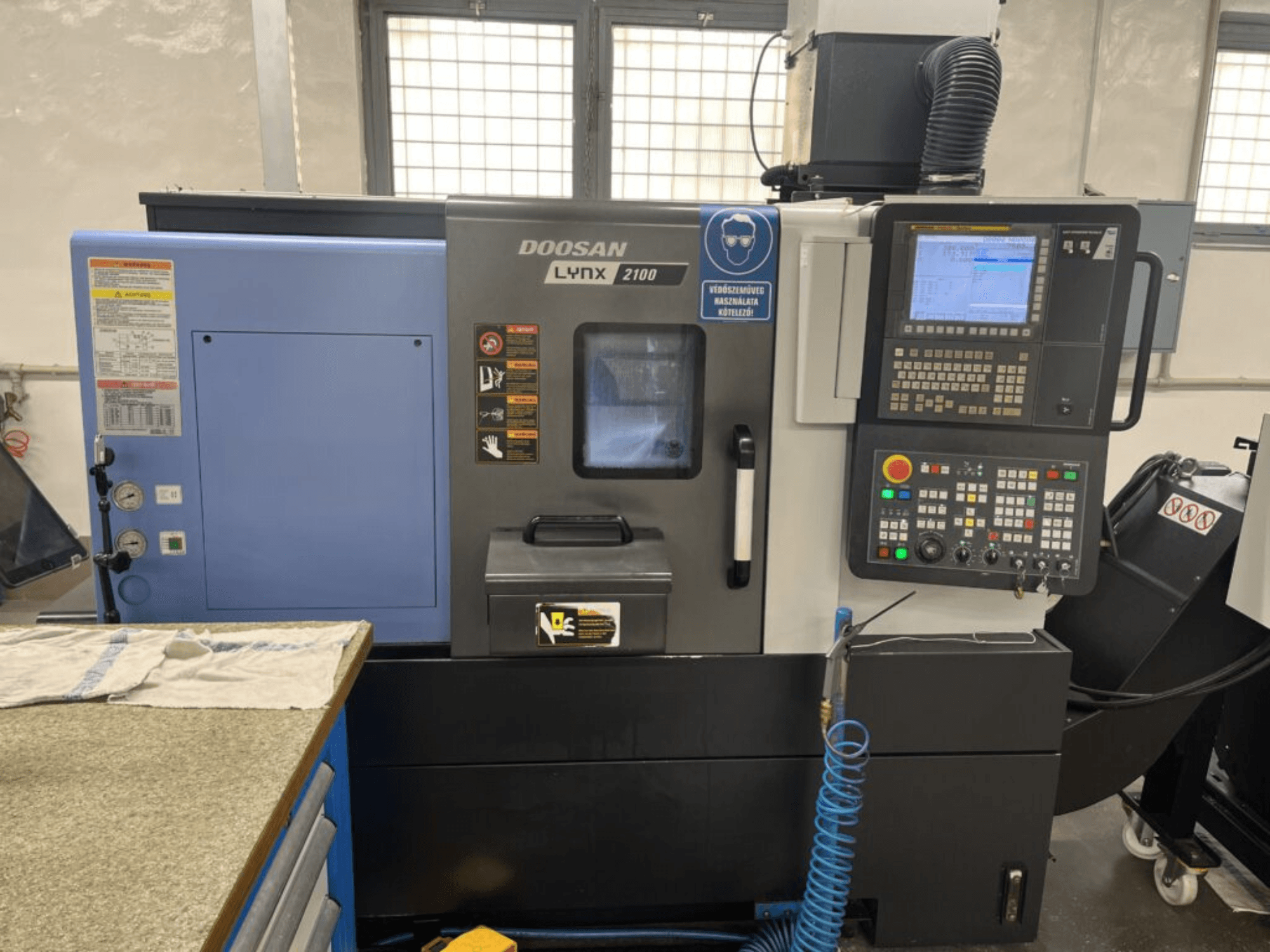 Горизонтальный токарный станок DOOSAN Lynx 2100A, вид спереди, демонстрирующий панель управления, интерфейс оператора и характеристики станка.