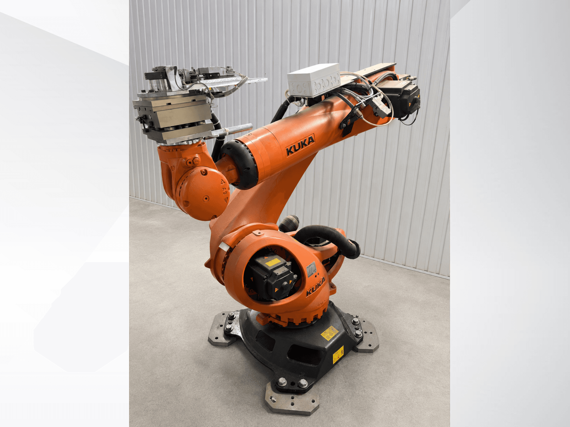 Дополнительный манипулятор робота KUKA KR 90 R3100 оранжевого цвета, вид сбоку, на котором видны шарниры, контроллер и крепеж инструмента на концевом эффекторе.