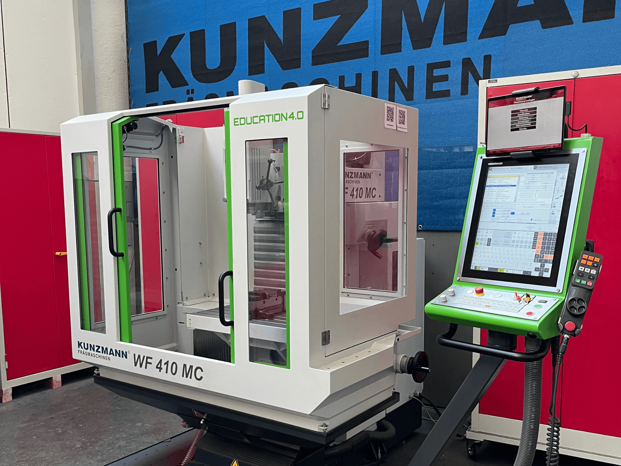 Универсальный обрабатывающий центр KUNZMANN WF 410 MC в виде спереди, с зелеными акцентами, прозрачными дверцами и панелью управления.
