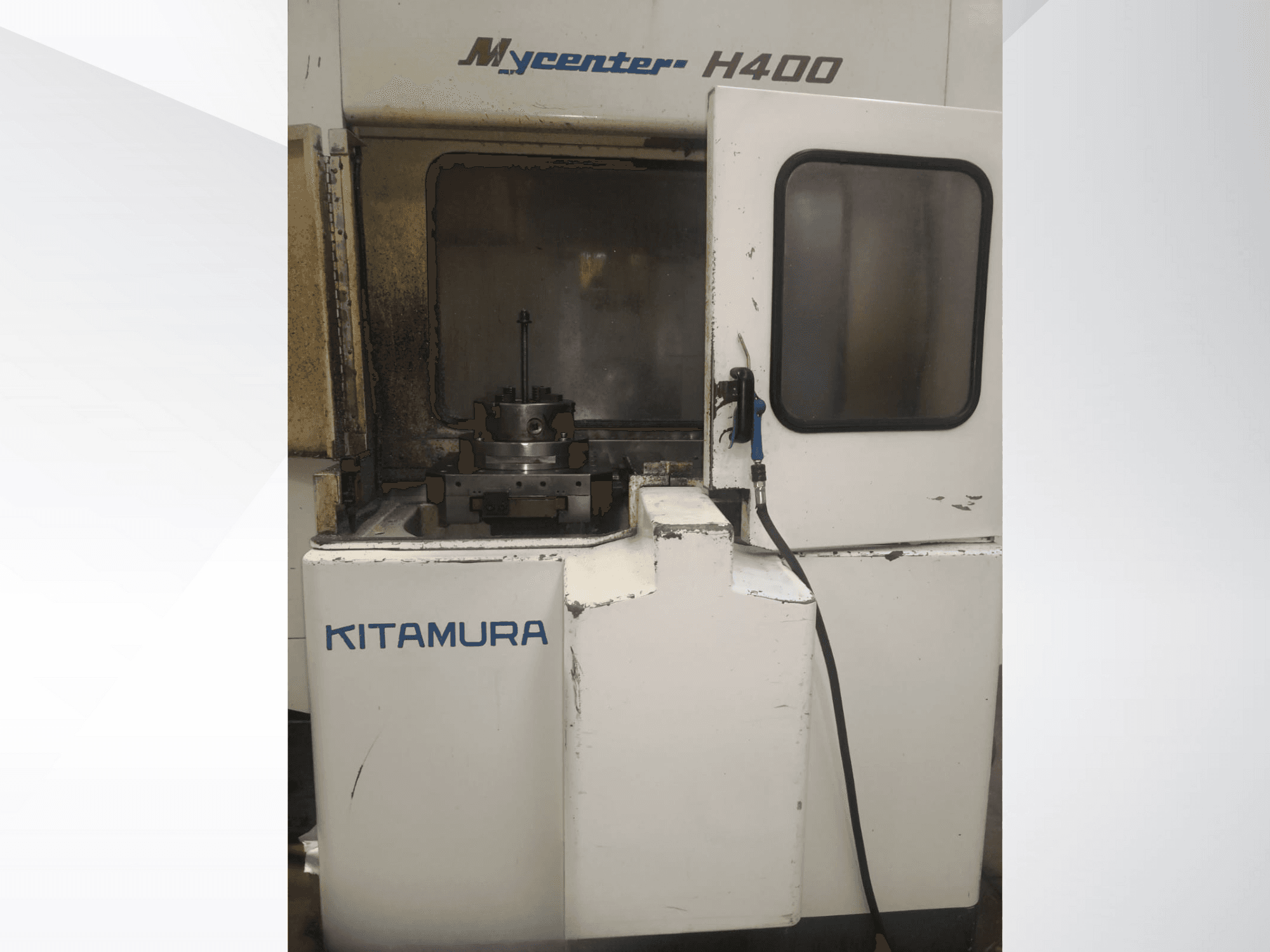 Станок с ЧПУ Kitamura Mycenter H400, вид спереди, с видимой рабочей областью и панелью управления, со следами эксплуатации.