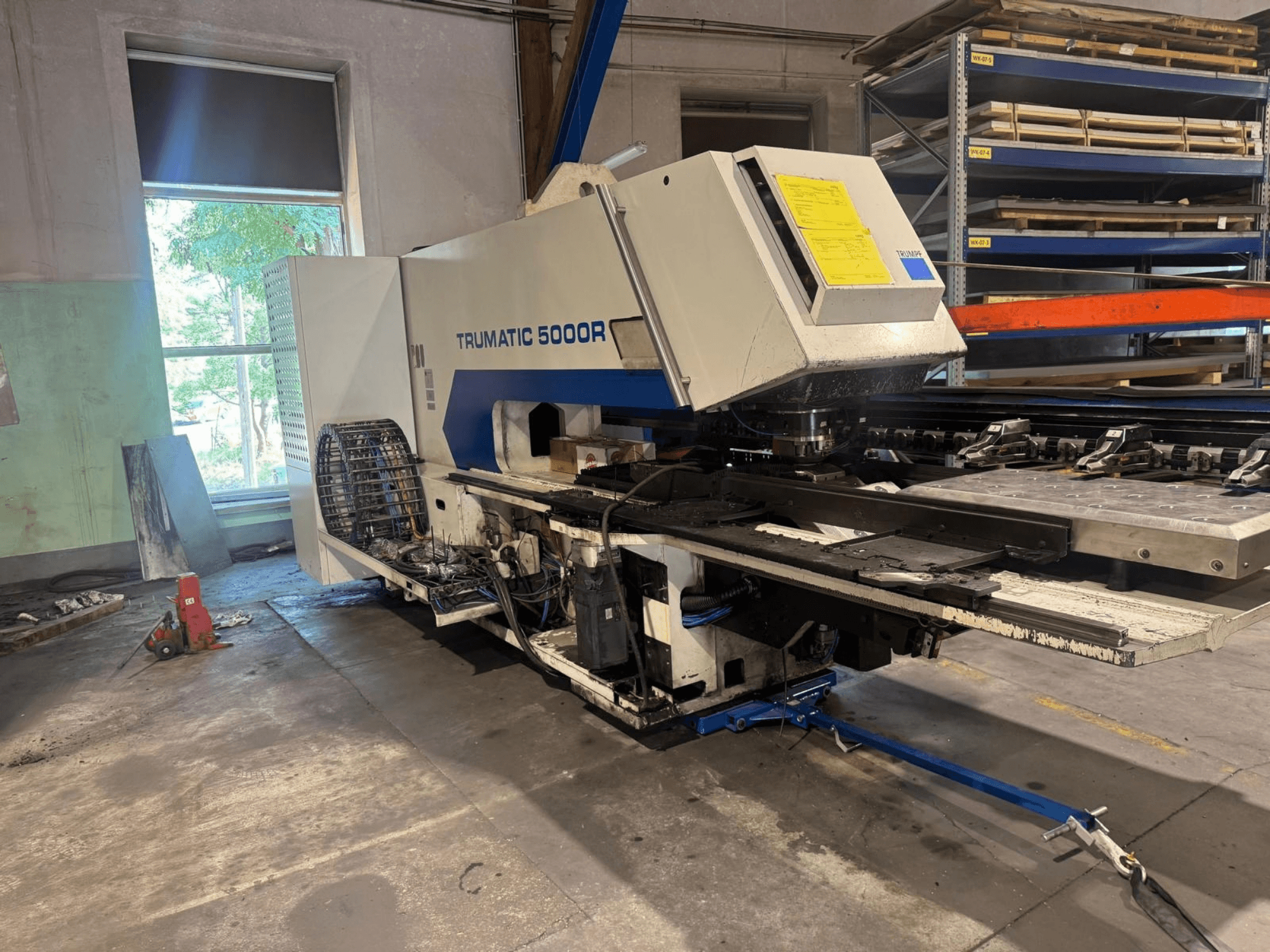 Штамповочный станок с ЧПУ TRUMPF TRUMATIC 5000R в цехе, вид спереди, на котором видны органы управления и зона штамповки.