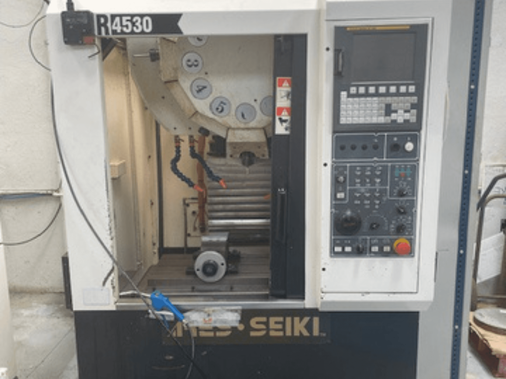 Вертикальный обрабатывающий центр ARES-SEIKI R4530, вид спереди, демонстрирующий панель управления и рабочую зону со шпинделем и системой подачи СОЖ.