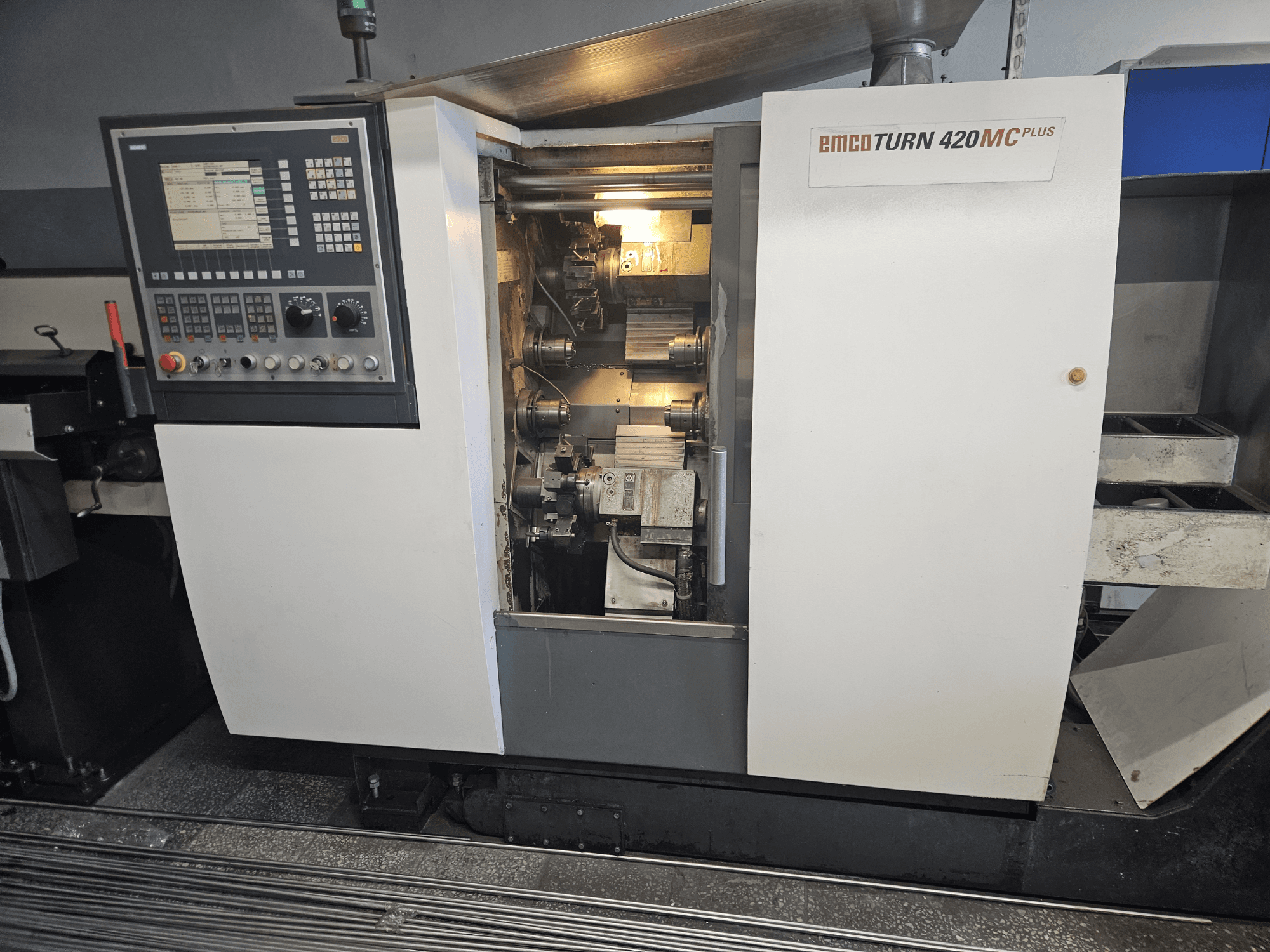Многошпиндельный станок EMCO TURN 420 MC Plus, вид спереди с изображением панели управления и внутренних компонентов.