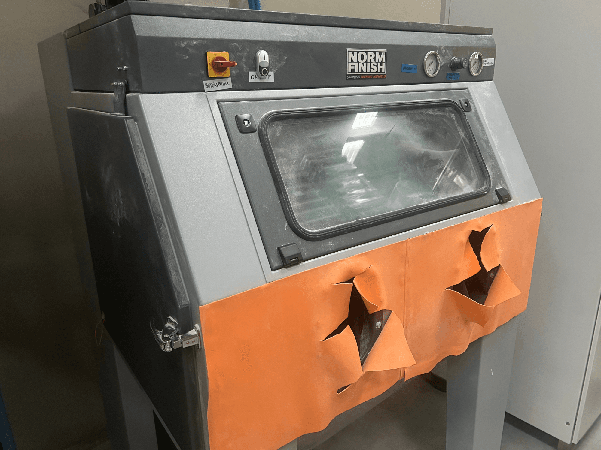 Пластиковый 3D-принтер EOS P 396 серого цвета, вид сбоку с потертой оранжевой крышкой и видимой панелью управления, в пыльном состоянии.