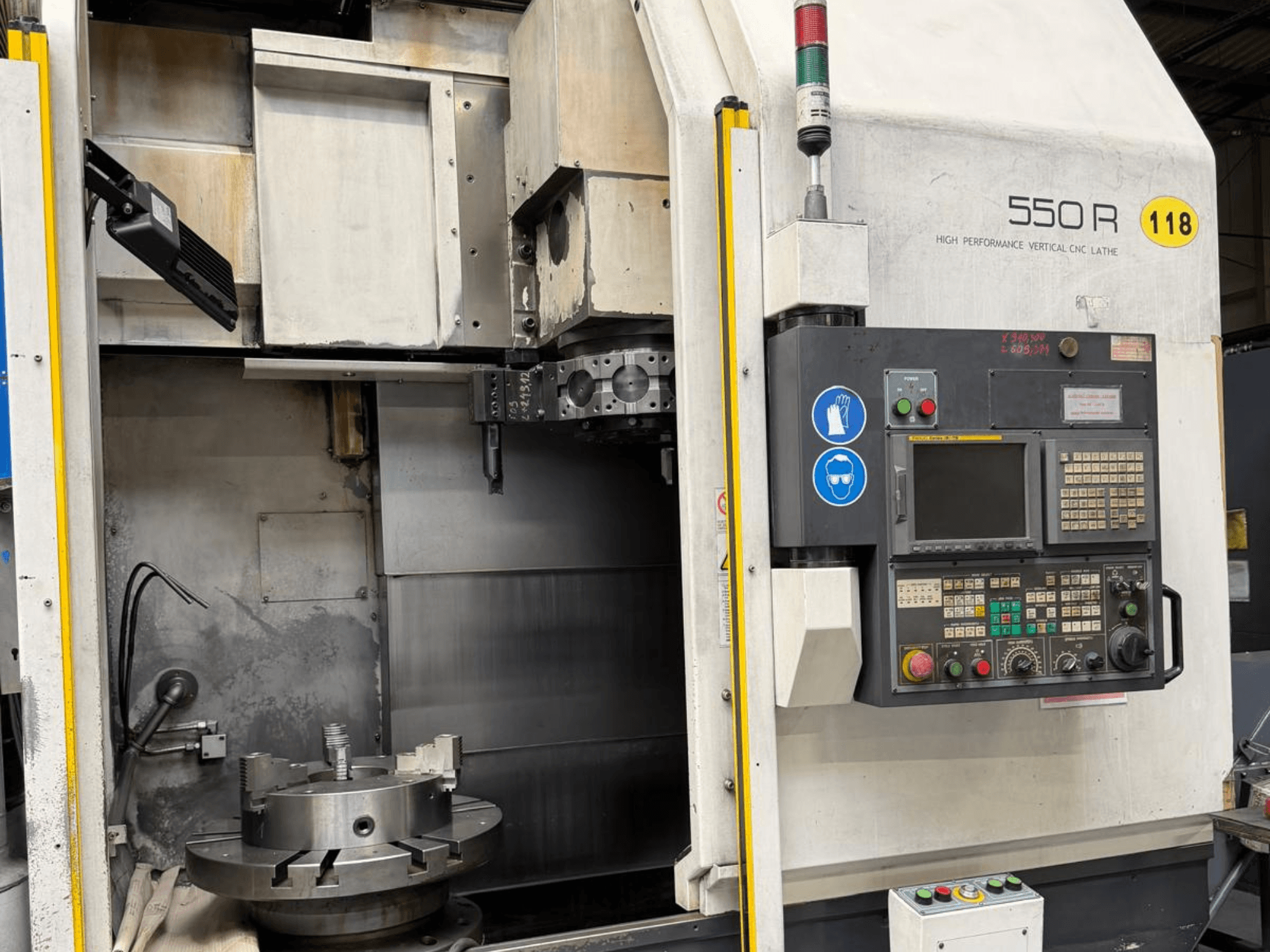 Высокопроизводительный вертикальный токарный станок с ЧПУ 550 R, вид спереди, показывает панель управления, вращающийся патрон и рабочие компоненты.