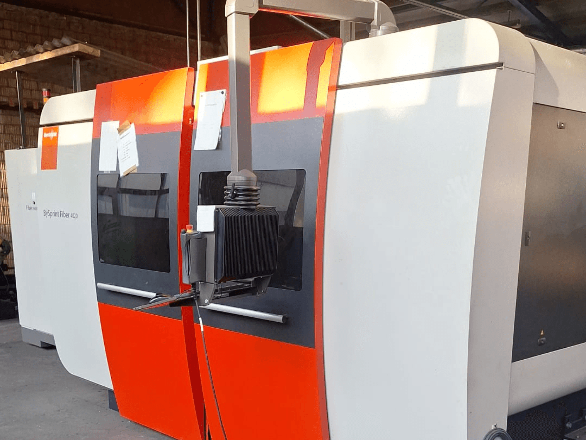 Станок лазерной резки BySprint Fiber 4020, вид сбоку, с красно-белой внешней стороной, видна подробная панель управления.