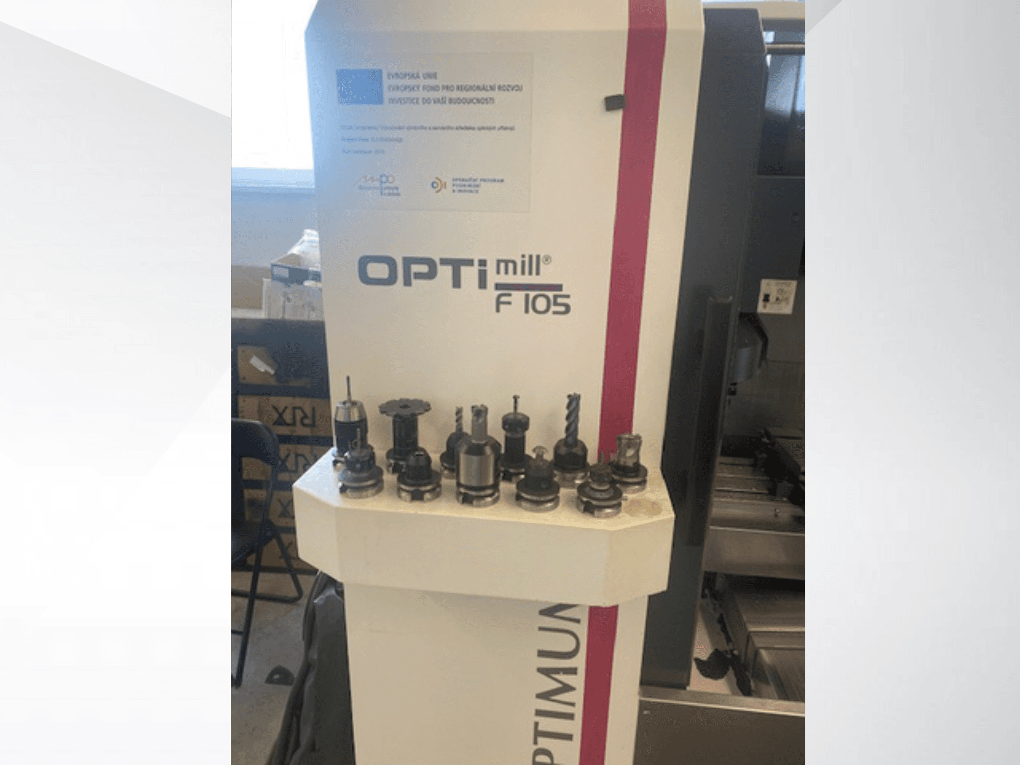 Вид спереди на вертикальный обрабатывающий центр Optimum Optimill F105 с различными установленными инструментами, представленными сбоку.