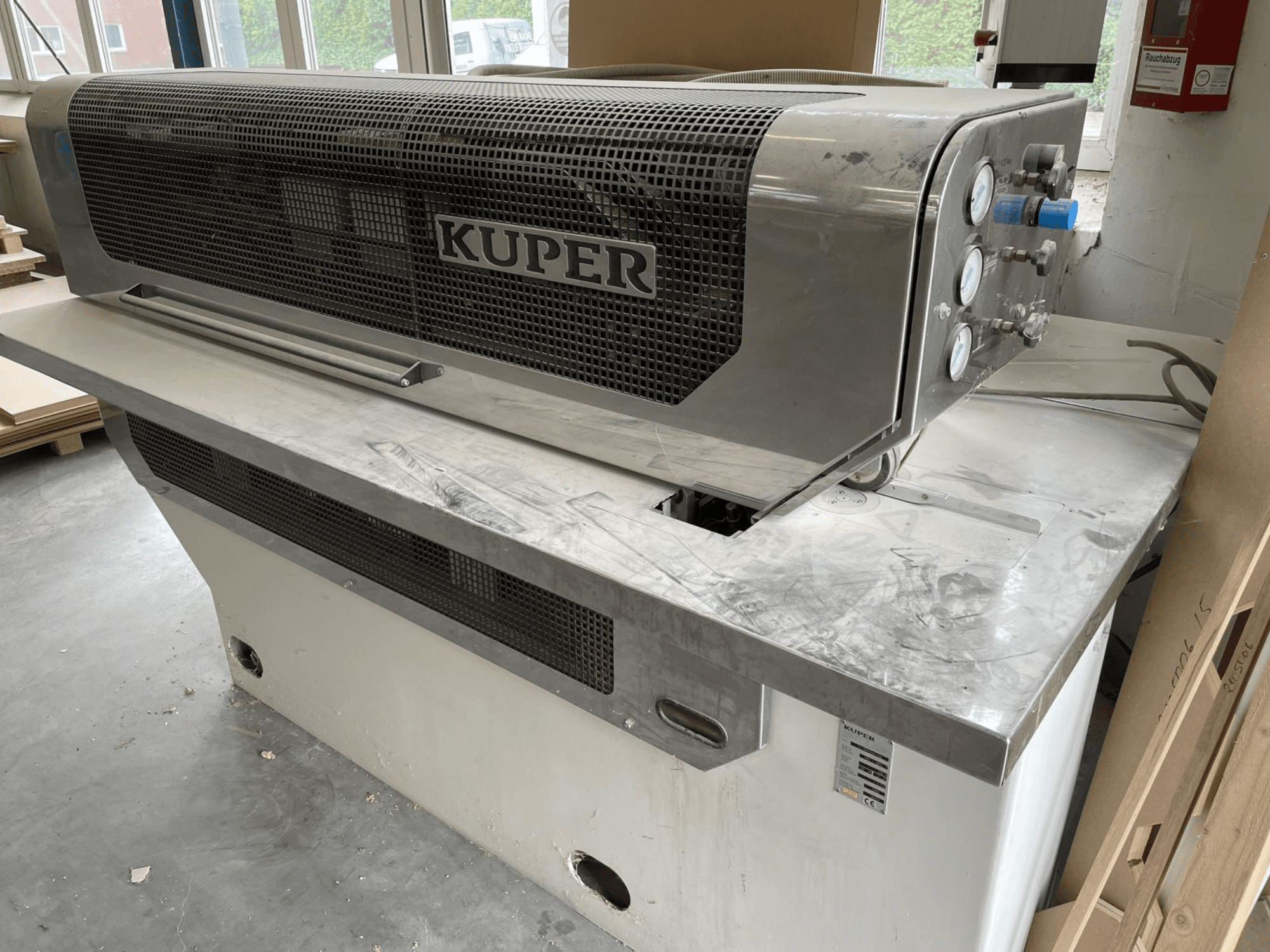 Гильотина для шпона KUPER FLI, вид спереди, корпус из нержавеющей стали, датчики и чистая зона реза на верстаке.