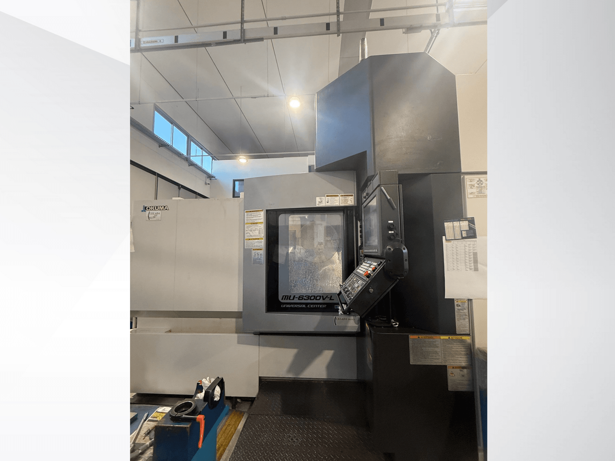 Станок с ЧПУ Okuma MU-6300V-L, вид спереди, панель управления и наклейки безопасности.