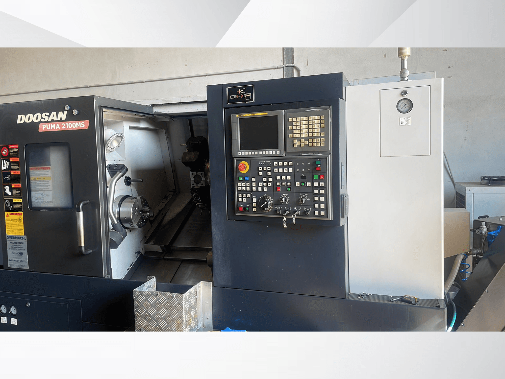Горизонтально-токарный станок DOOSAN PUMA 2100MS, вид спереди, на котором видны панель управления, шпиндель и режущие инструменты внутри рабочей камеры.
