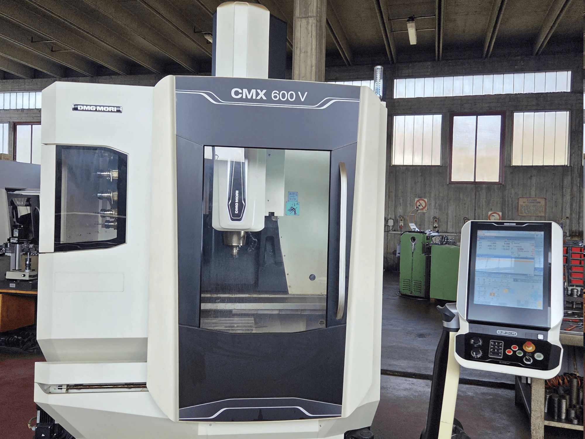 Вертикальный обрабатывающий центр DMG MORI CMX 600V в виде спереди с подробным изображением панели управления и области шпинделя.