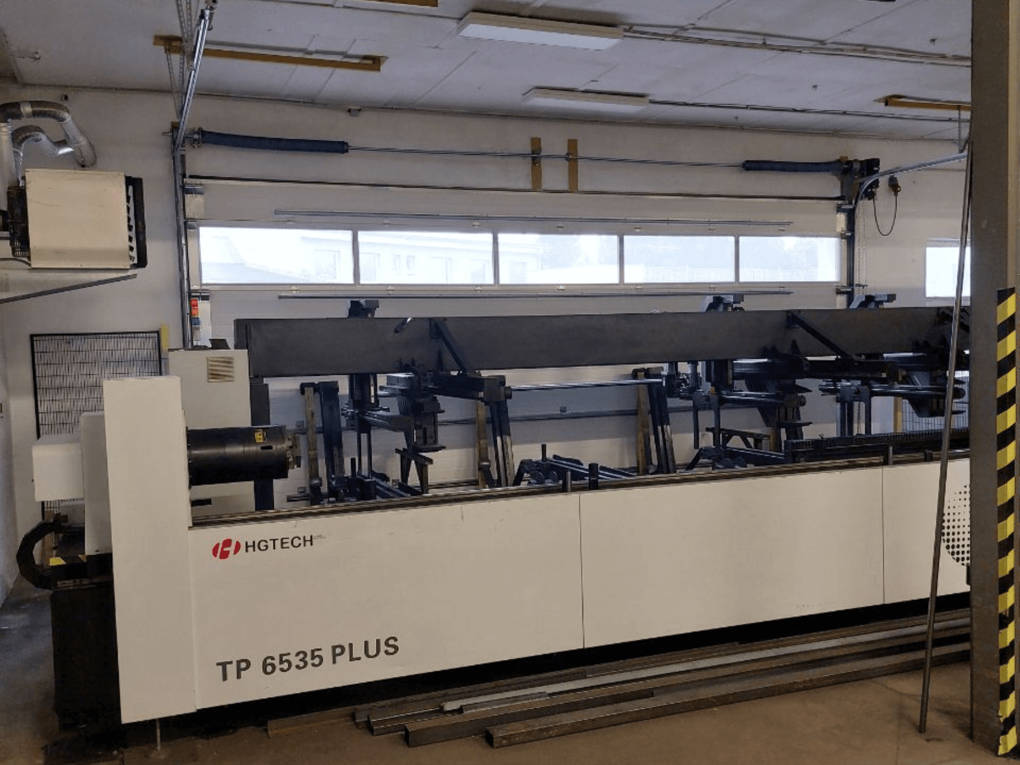 HGTECH TP 6535 PLUS, вид спереди на большой промышленный станок с несколькими манипуляторами для точного изготовления, установленный в мастерской.