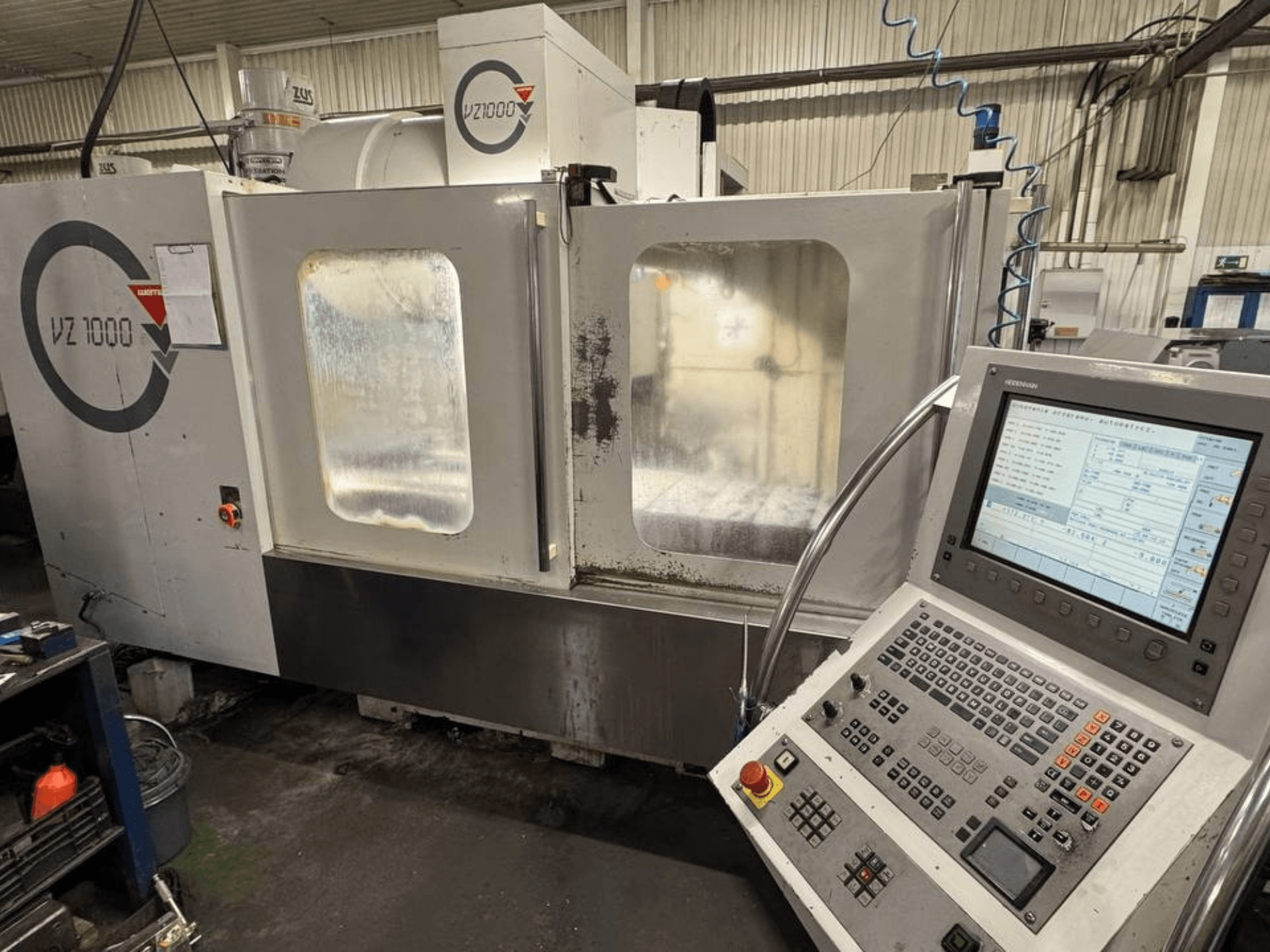 Вид спереди вертикального обрабатывающего центра WEMAS VZ 1000 с панелью управления и прозрачными дверцами.