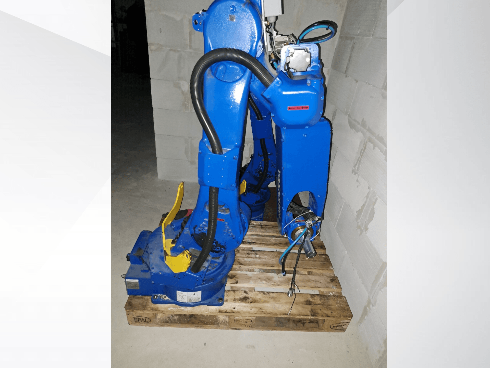Роботизированный манипулятор Yaskawa Motoman GP25 синего цвета, вид сбоку на деревянном поддоне, с кабелями и механическими соединениями.