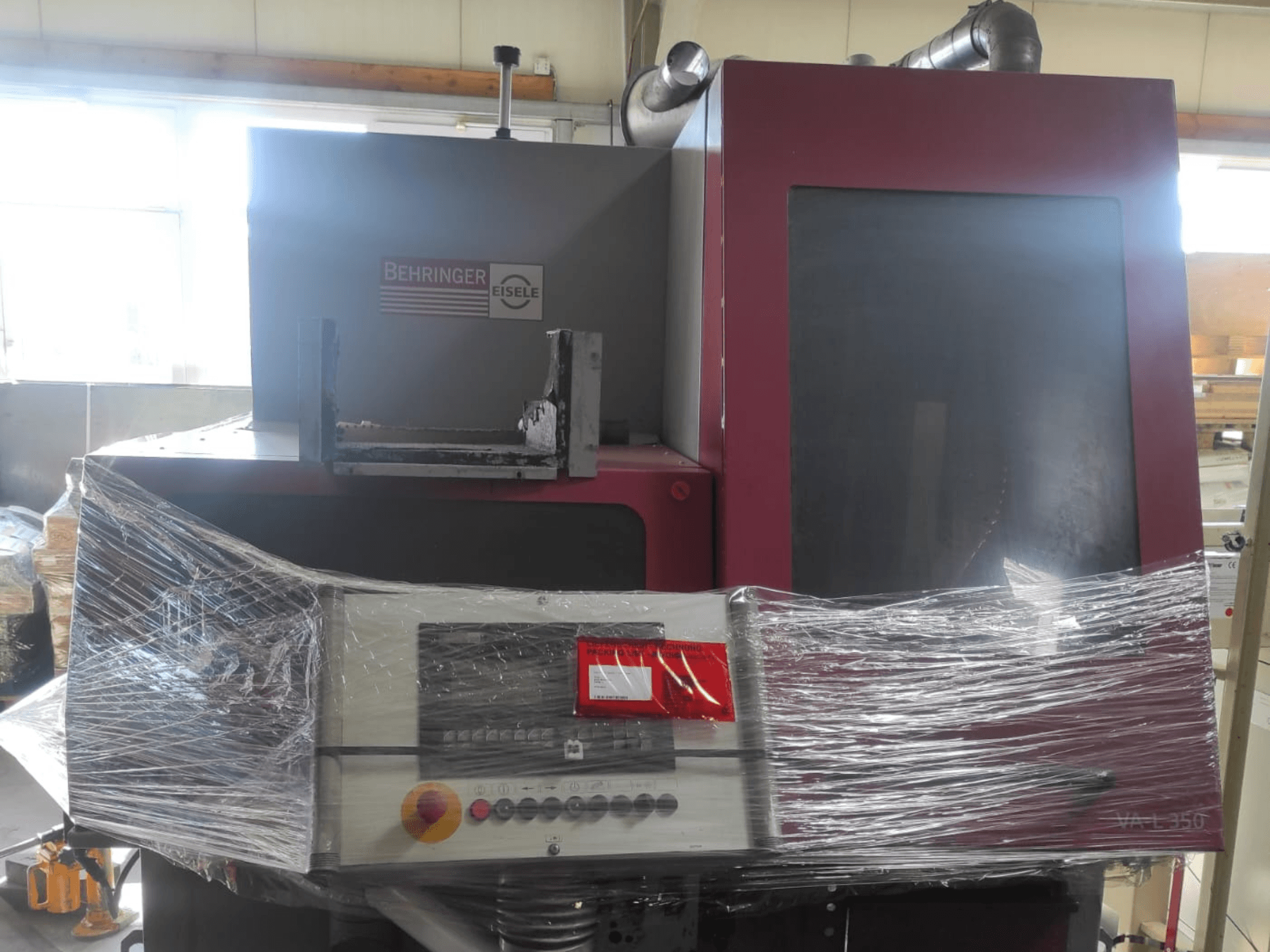 Машина Behringer Eisele VA L 560, вид спереди, обернутая пластиком, с панелью управления и кнопками, видимыми.