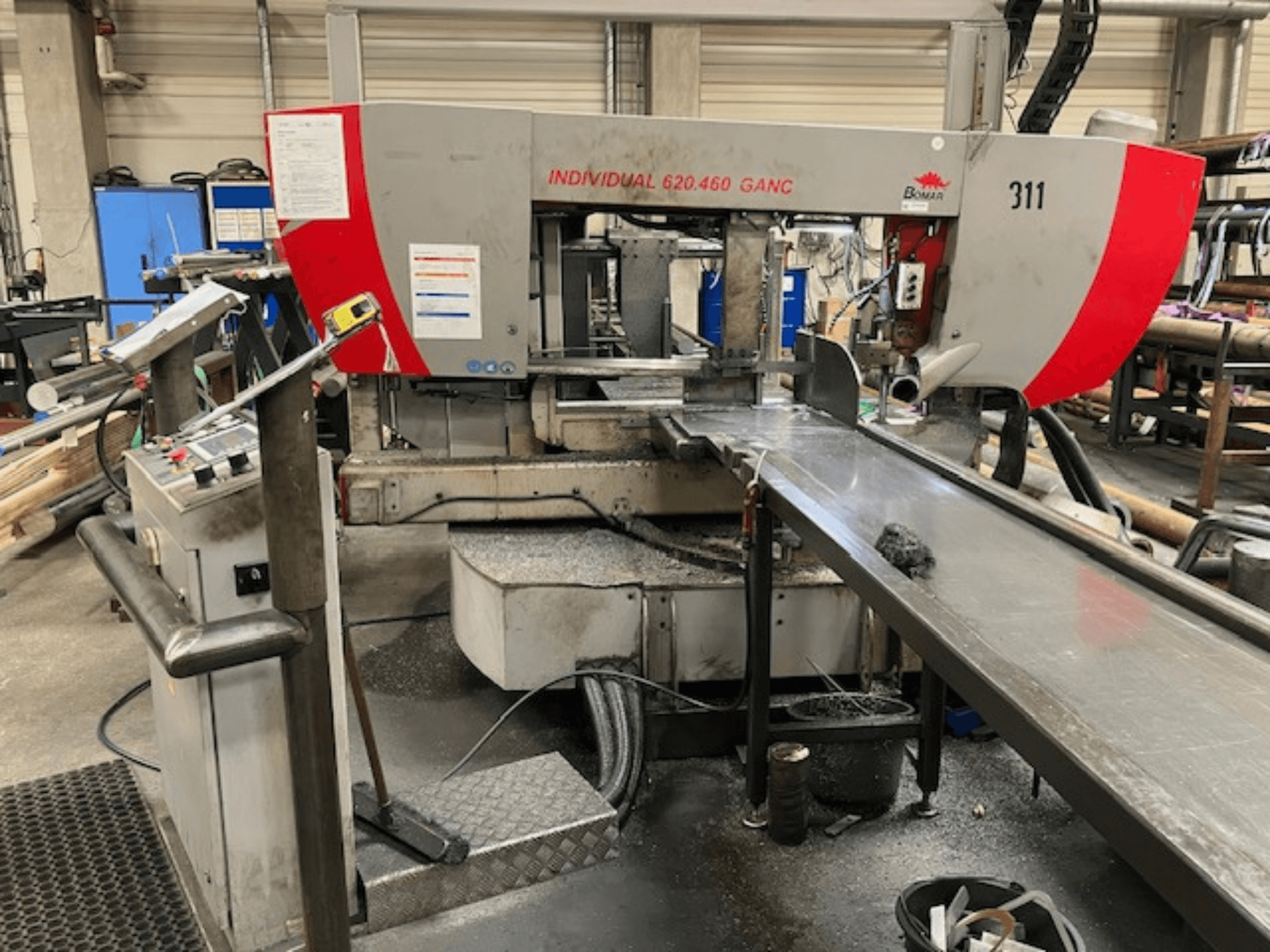 Ленточная пила BOMAR INDIVIDUAL 620-460 GANC, вид спереди, видны органы управления, зона резания и фон промышленного цеха.