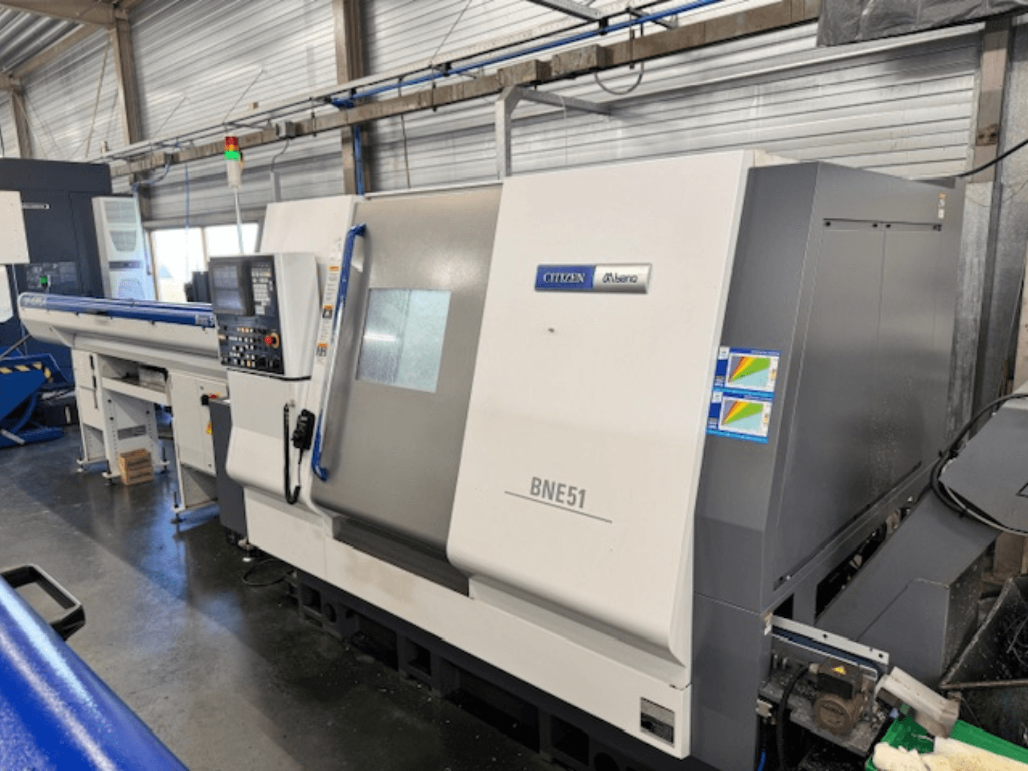 Горизонтальный токарный станок Citizen BNE-51MSY, вид сбоку, демонстрирующий панель управления и механизм подачи.