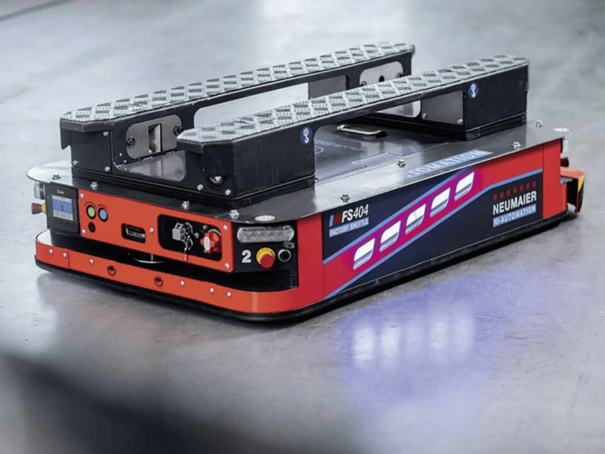 NEUMAIER AGV Factory Shuttle FS404, низкопрофильная система перемещения паллет, вид сбоку, демонстрирующий колеса, органы управления и средства безопасности.