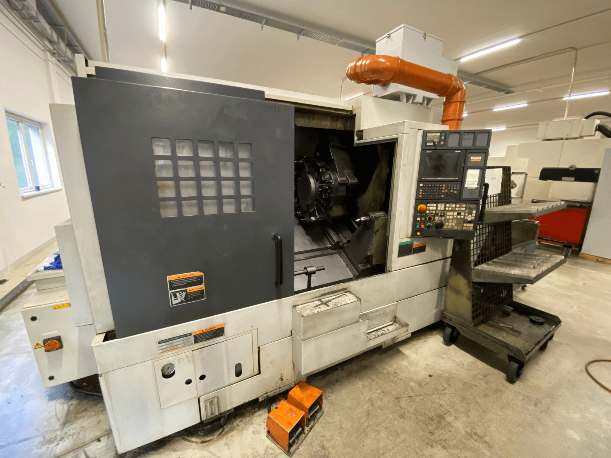 Токарно-фрезерный центр DMG Mori Seiki NL2500Y/700, вид спереди с деталями панели управления и кожуха станка.