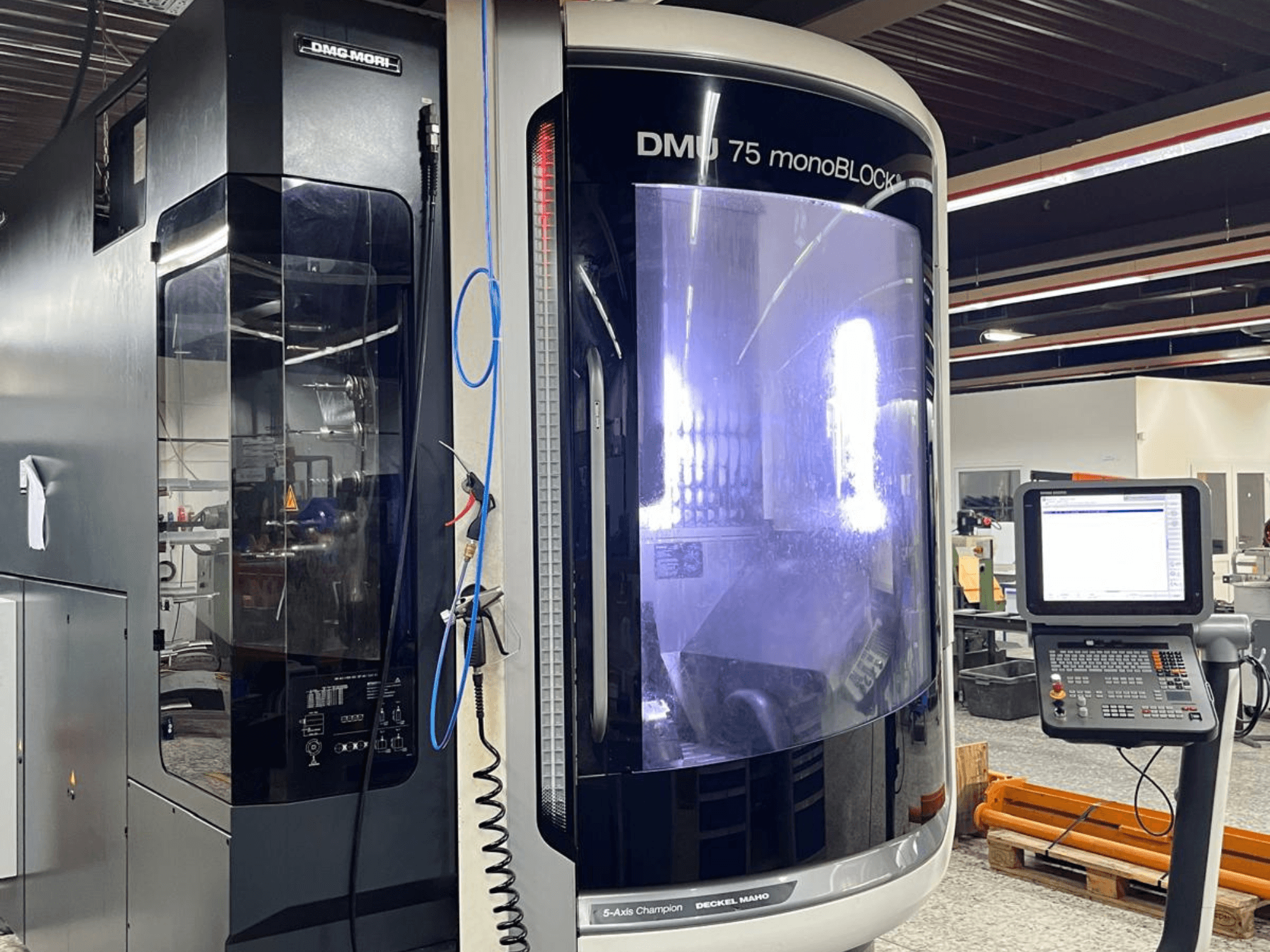 Универсальный обрабатывающий центр DMG MORI DMU 75 MonoBlock, вид спереди, демонстрирует панель управления и отличительный корпус.