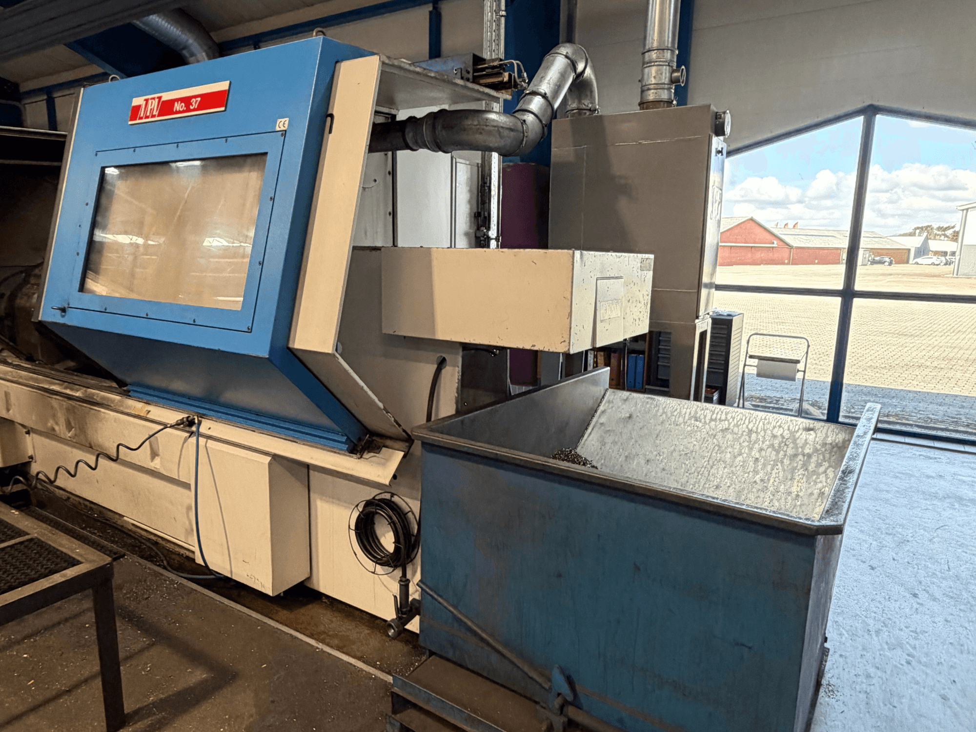 Горизонтальный токарный станок BOEHRINGER VDF 315 CM, вид спереди, демонстрирующий синюю панель и контейнер для сбора отходов.