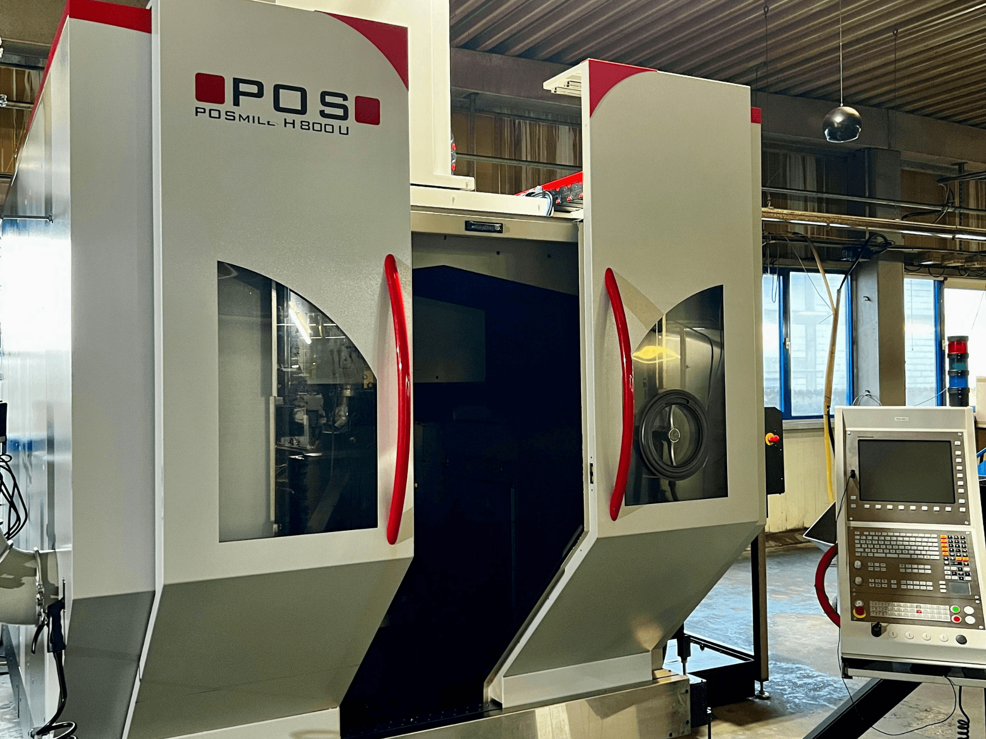 Универсальный обрабатывающий центр POSmill H800U, вид спереди с панелью управления и открытыми дверцами, через которые видны внутренние компоненты.
