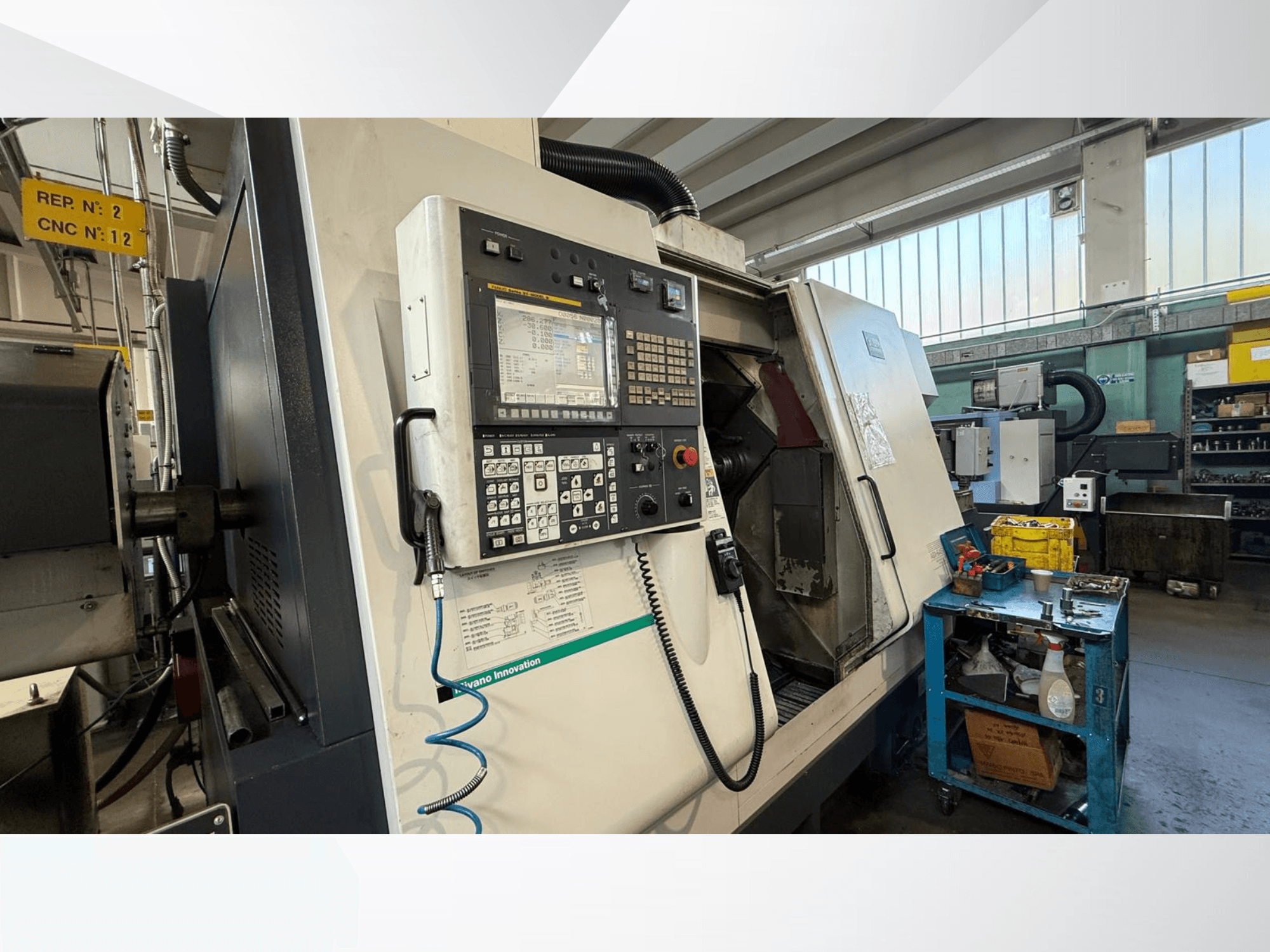 Горизонтальный токарный станок Miyano ABX64 YY2 с видом спереди, с панелью управления, с инструментами и оборудованием в мастерской.