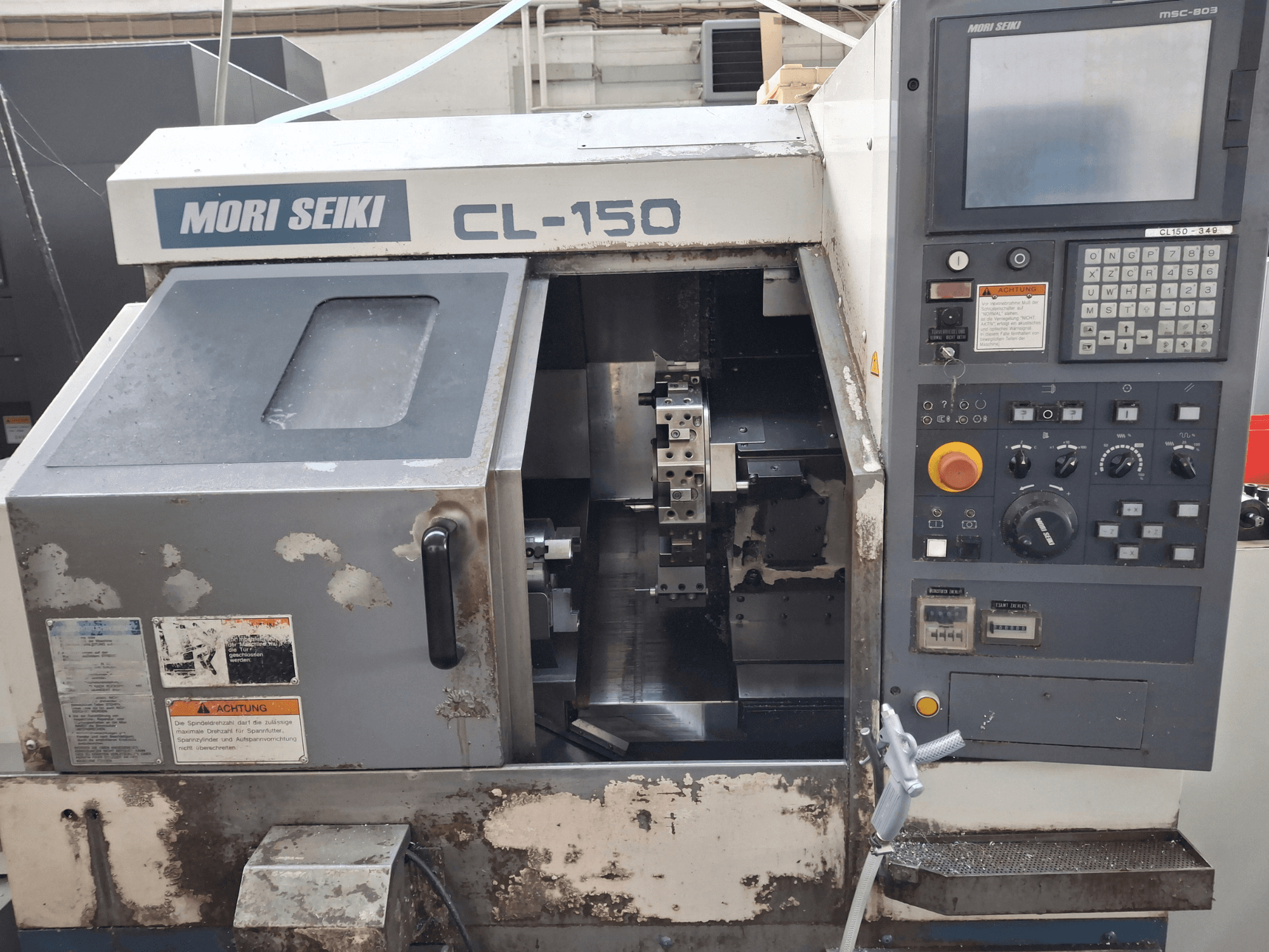 Горизонтальный токарный станок MORI SEIKI CL-150, вид спереди. Панель управления, режущие инструменты и индикаторы работы.