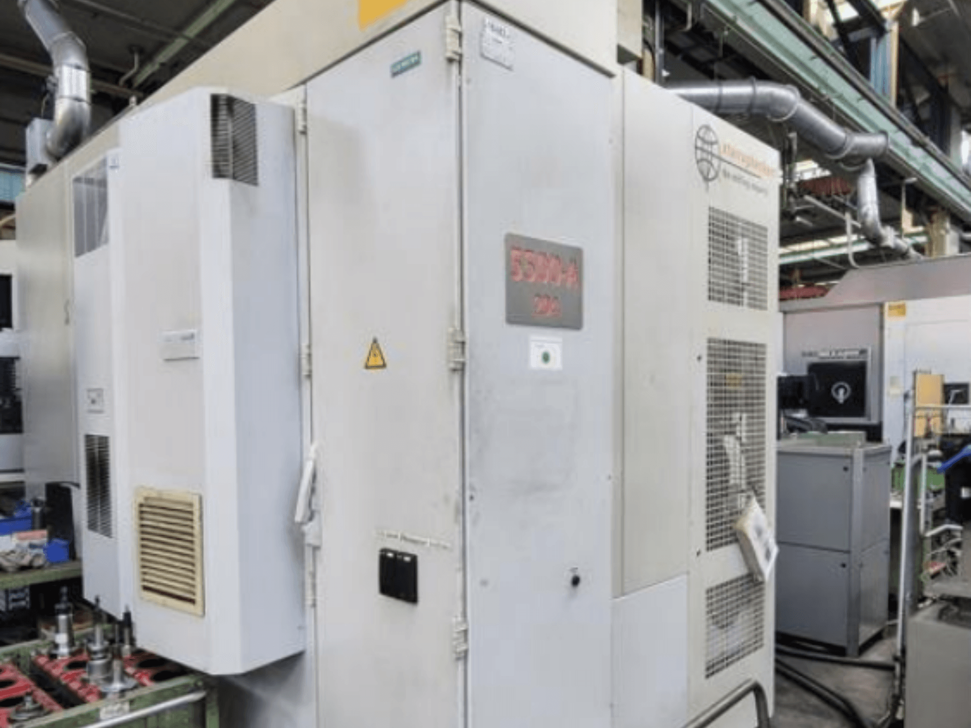 Горизонтальный обрабатывающий центр Starrag Heckert HEC 500 H/V, вид сбоку с вентиляционными отверстиями и предупреждающей надписью.
