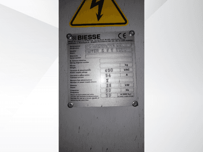 Табличка с техническими характеристиками обрабатывающего центра Biesse NC, отображающая данные о напряжении, весе и мощности, вид сбоку.