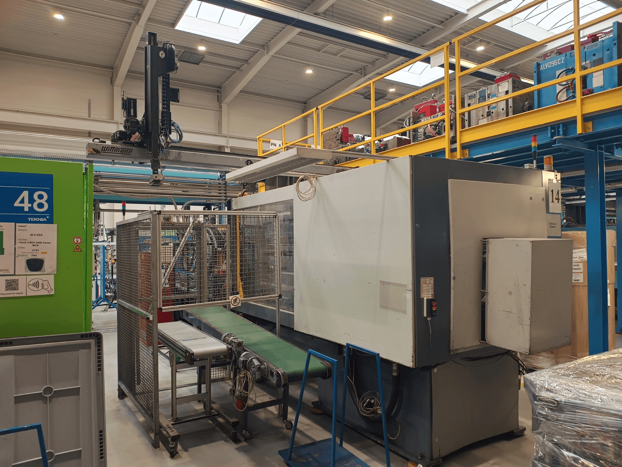 Промышленная автоматическая машина Winmon, вид сбоку с изображением конвейерной ленты, панели управления и защитной клетки в заводских условиях.