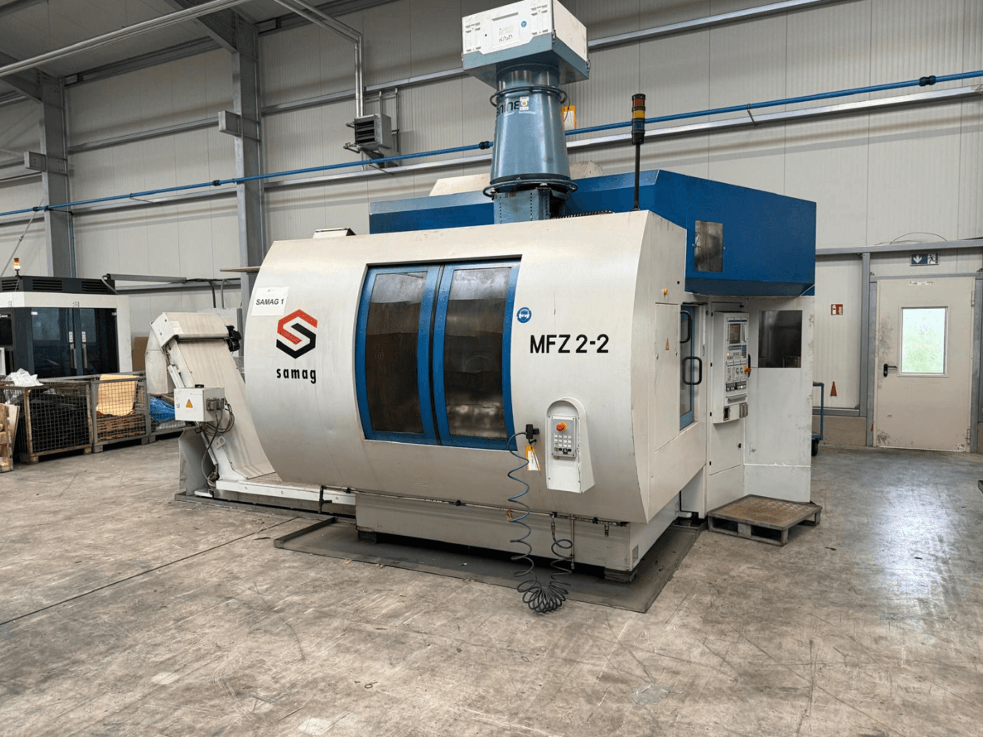 Станок Samag MFZ 2-2, вид спереди, с изображением панели управления и синего верха, с элементами безопасности в промышленной обстановке.