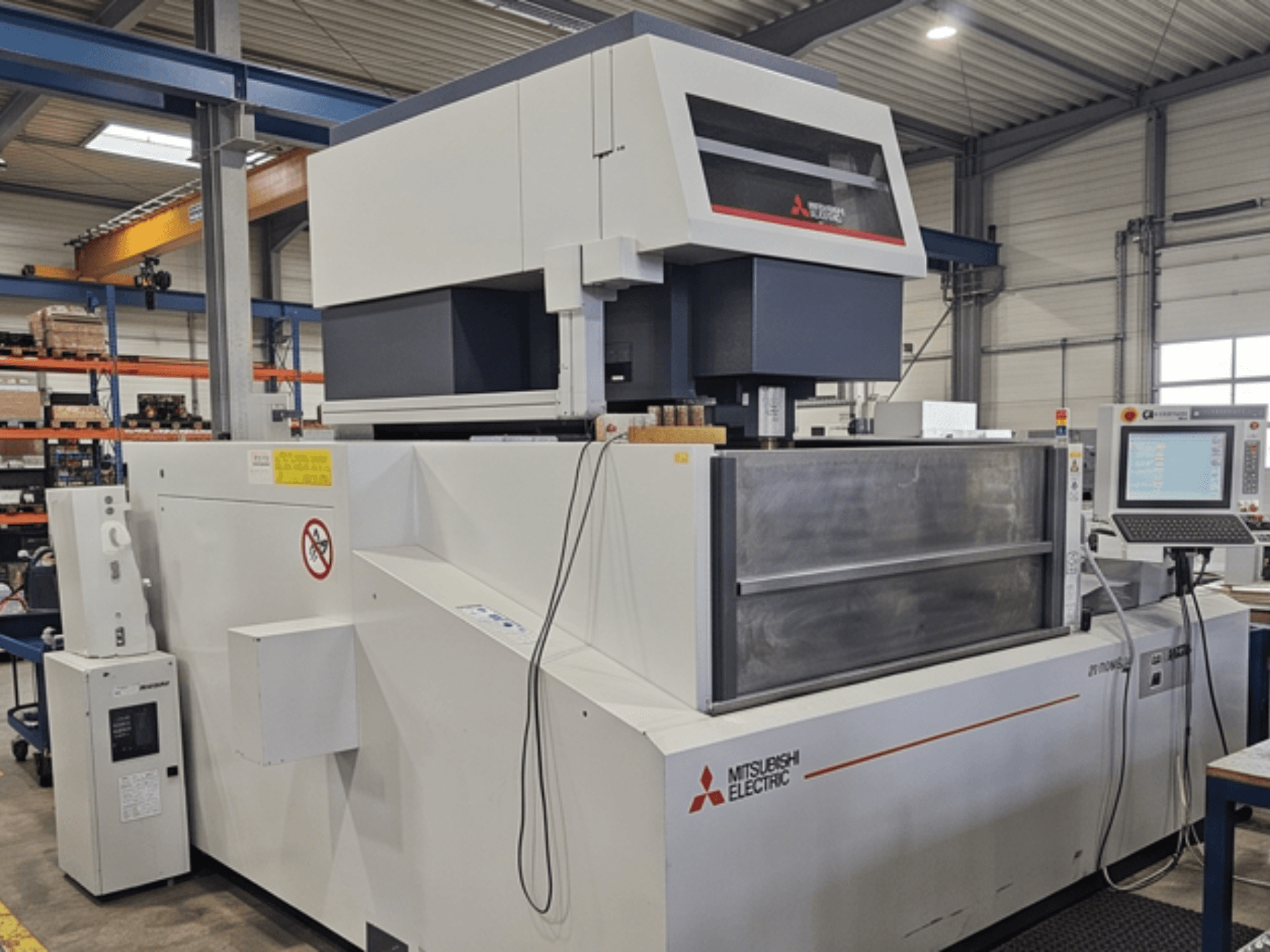 Электроэрозионный станок Mitsubishi MV-4800, вид спереди, на котором видны панель управления и рабочая зона в заводских условиях.