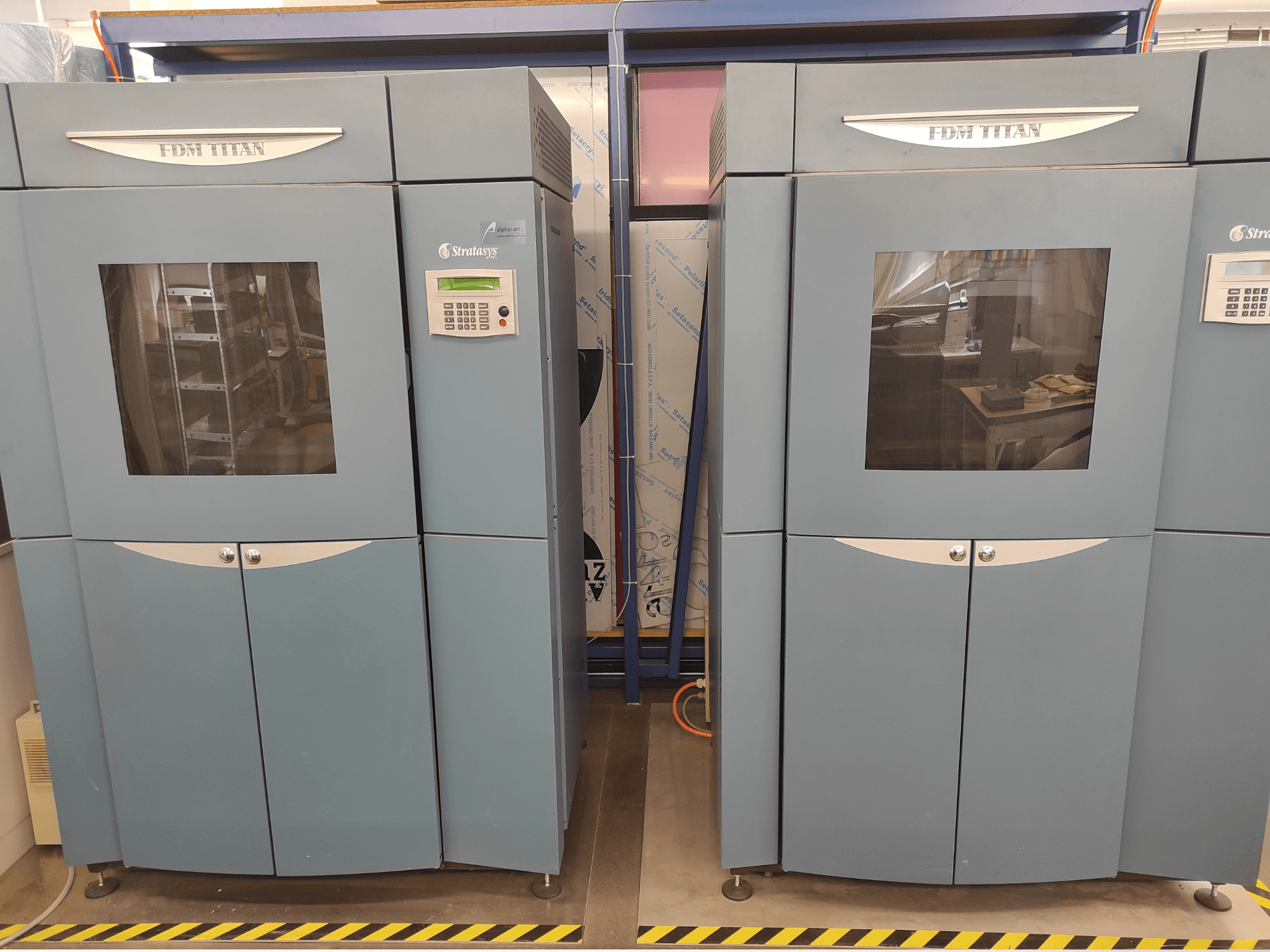 Вид спереди на пластиковый 3D-принтер Stratasys FDM TitanTI T0031; на нем видны панель управления и прозрачное окно.