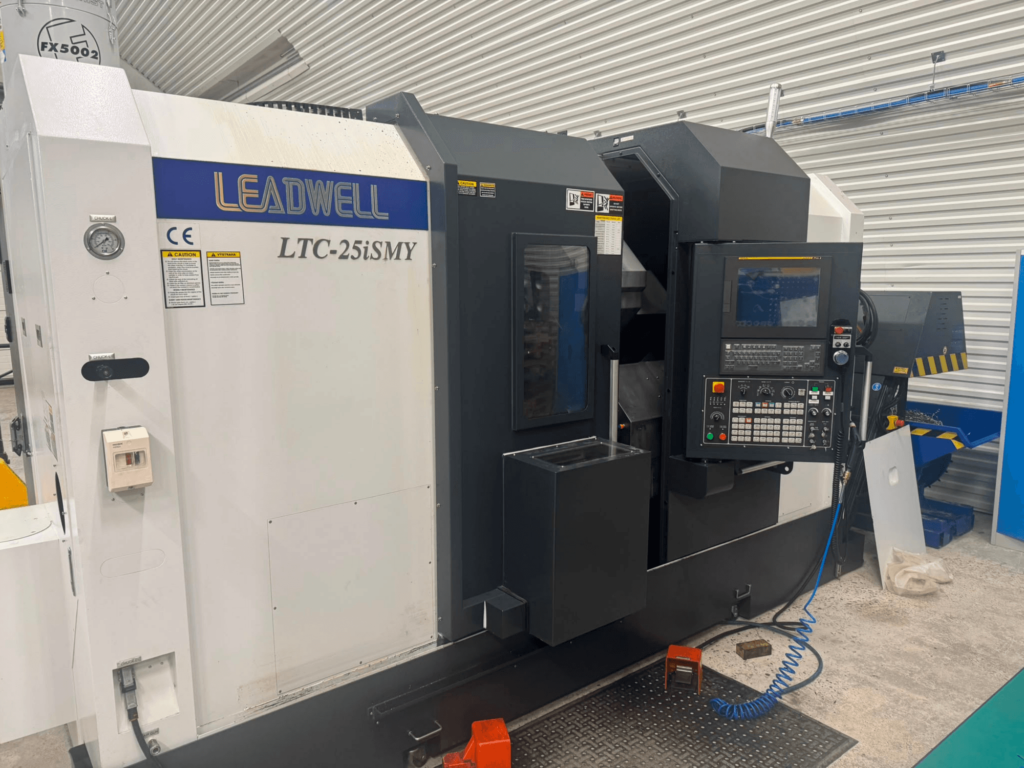 Горизонтальный токарный станок Leadwell LTC-25iSMY, вид спереди, на котором видны панель управления и рабочие интерфейсы.