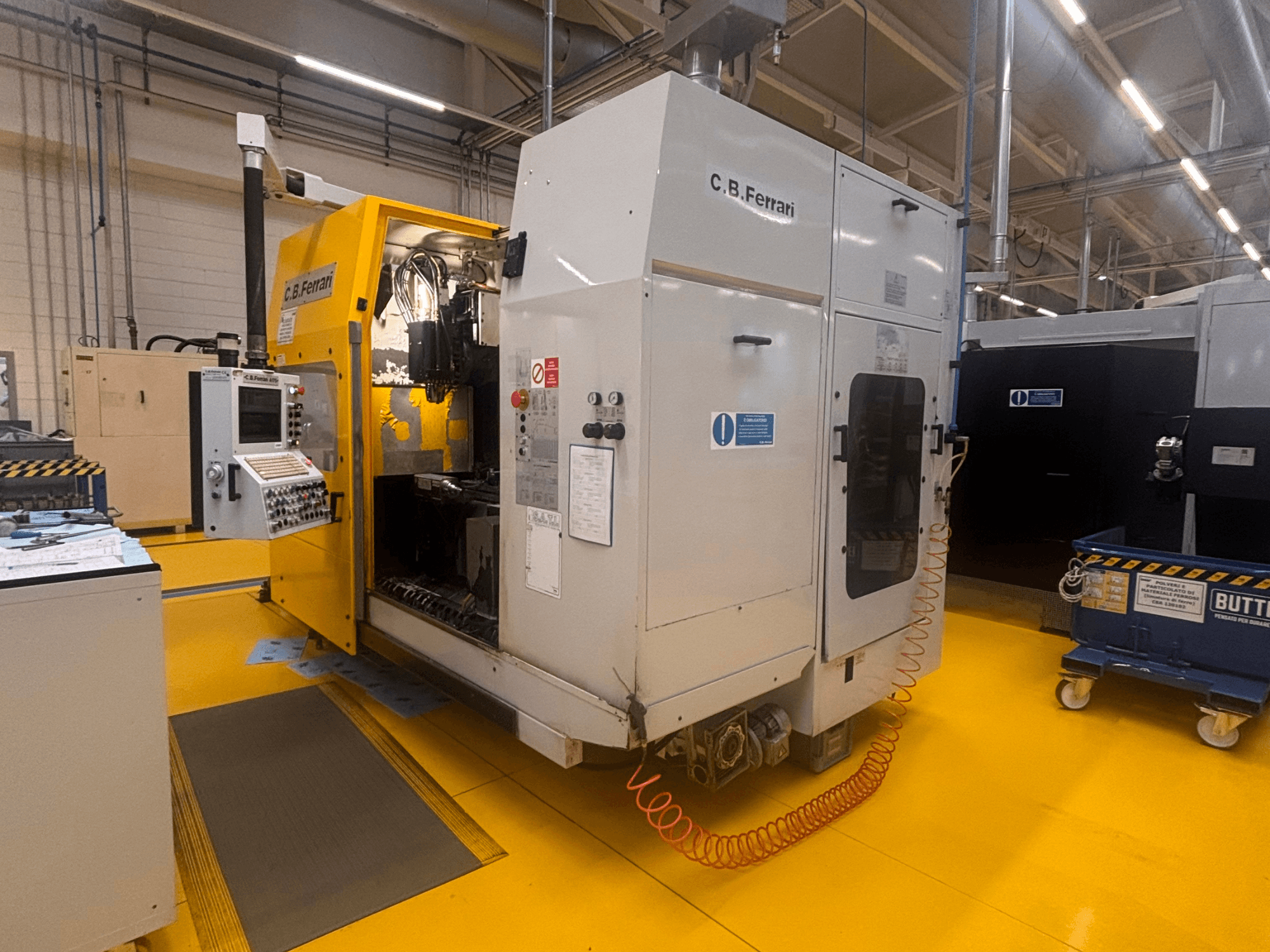 Вертикальный обрабатывающий центр C.B. Ferrari A175 в заводских условиях, вид спереди, видна панель управления и открытая дверца доступа.