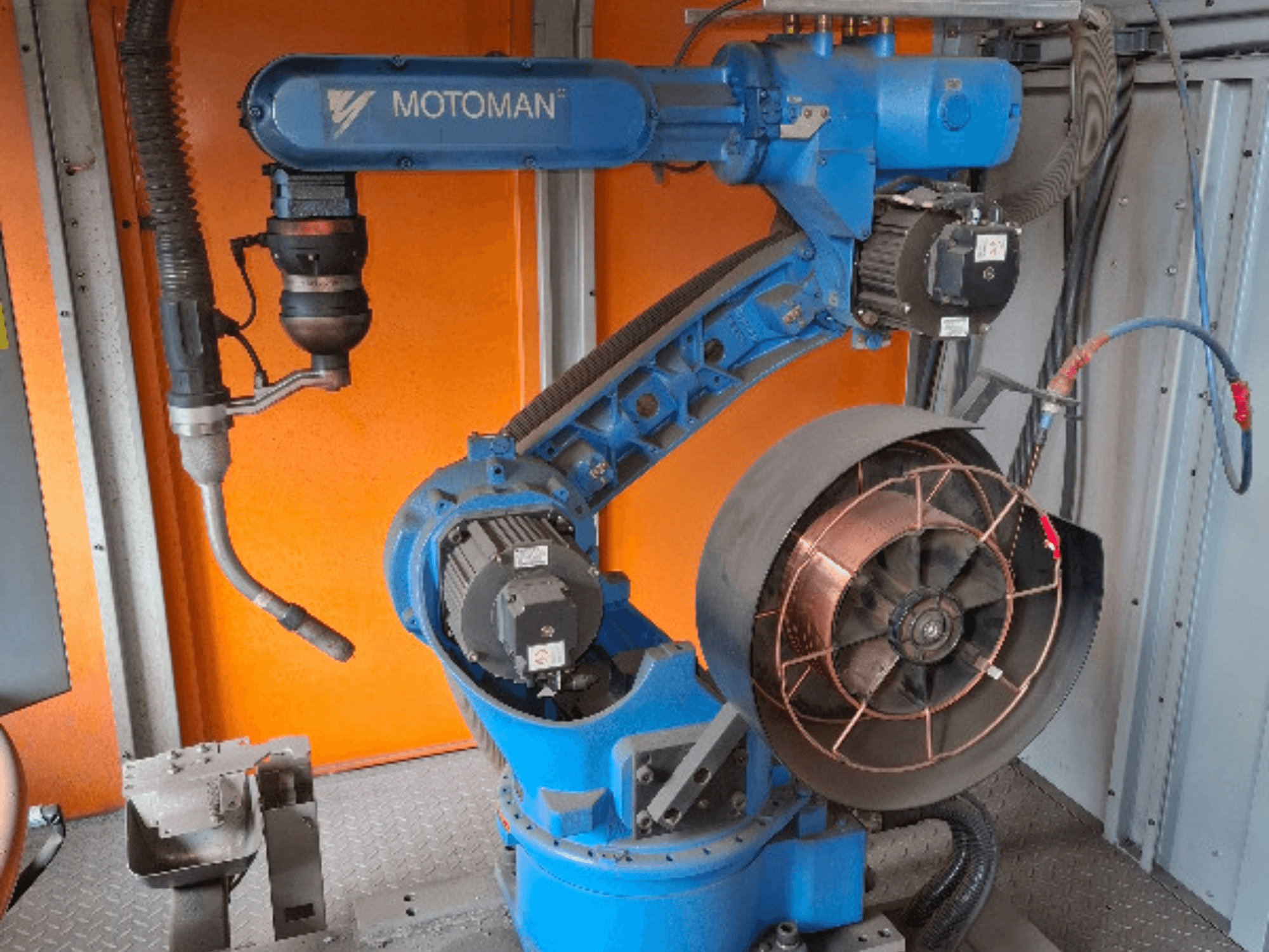 Роботизированная рука MOTOMAN синего цвета, вид сбоку, с прикрепленным вентилятором и инструментами, с изображением механических деталей и соединений.