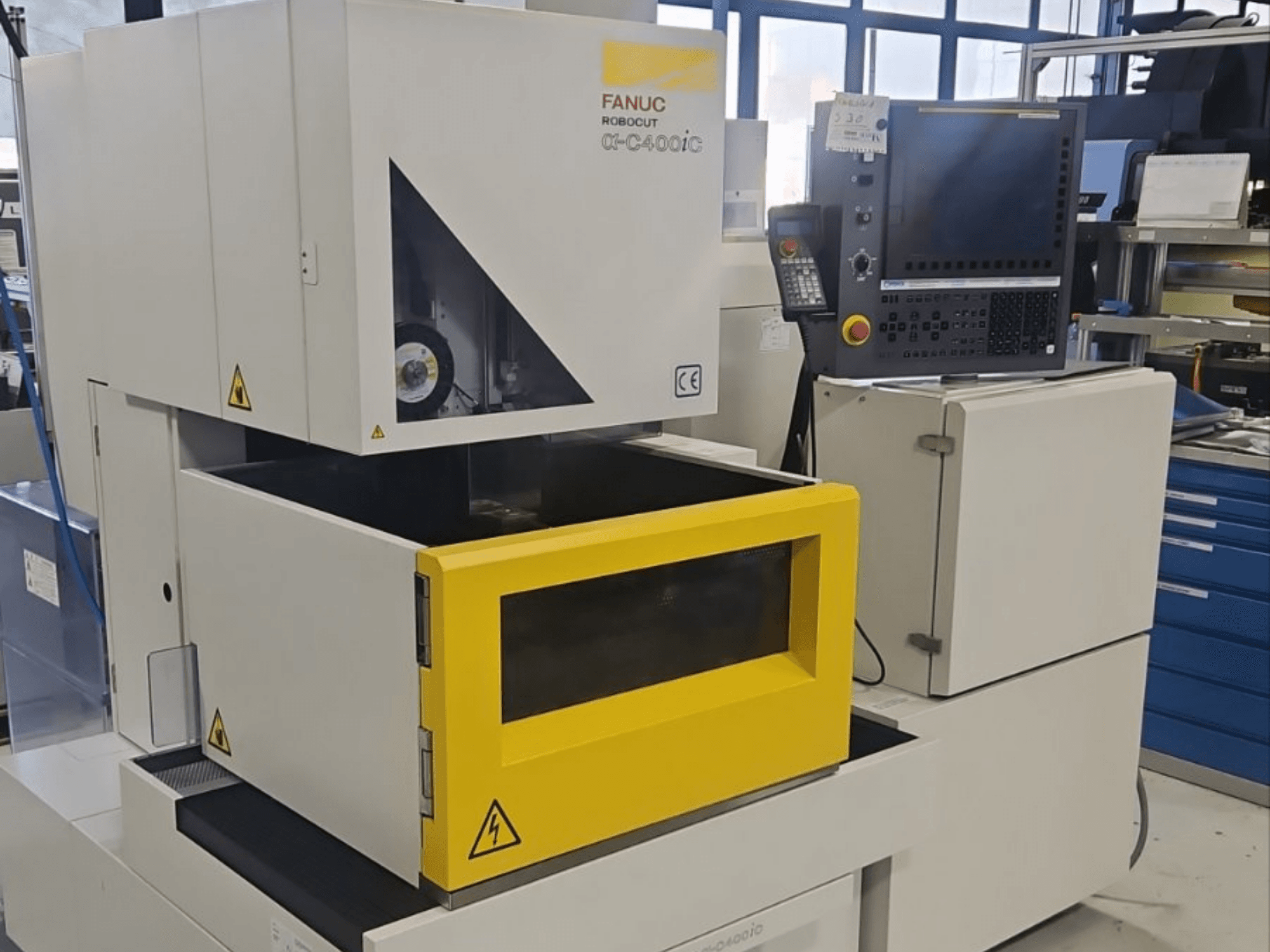 Электроэрозионный станок FANUC Robocut alpha-C400iC для глубокой электроэрозии в виде спереди, с желтой камерой для заготовки и панелью управления.