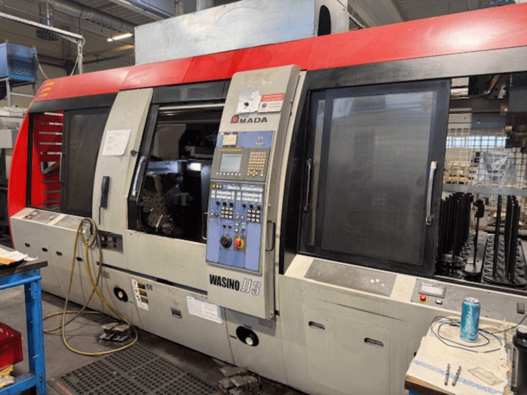 Горизонтальный токарный станок AMADA Wasino JJ3, вид спереди, демонстрирующий панель управления и открытую камеру для обработки.