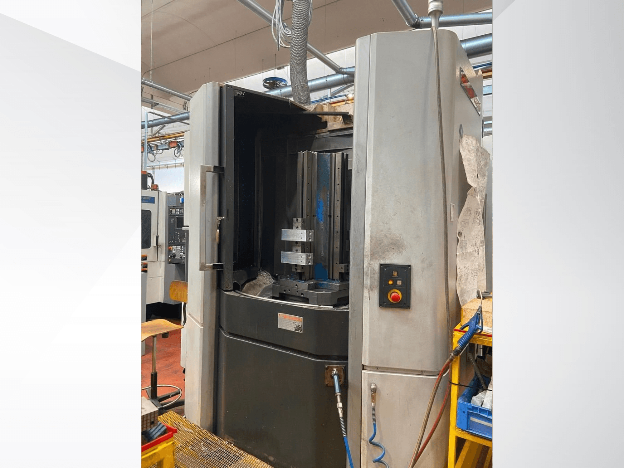 Горизонтальный обрабатывающий центр MORI SEIKI NHX 5000, вид спереди с открытой дверью, держателем инструмента и панелью управления.