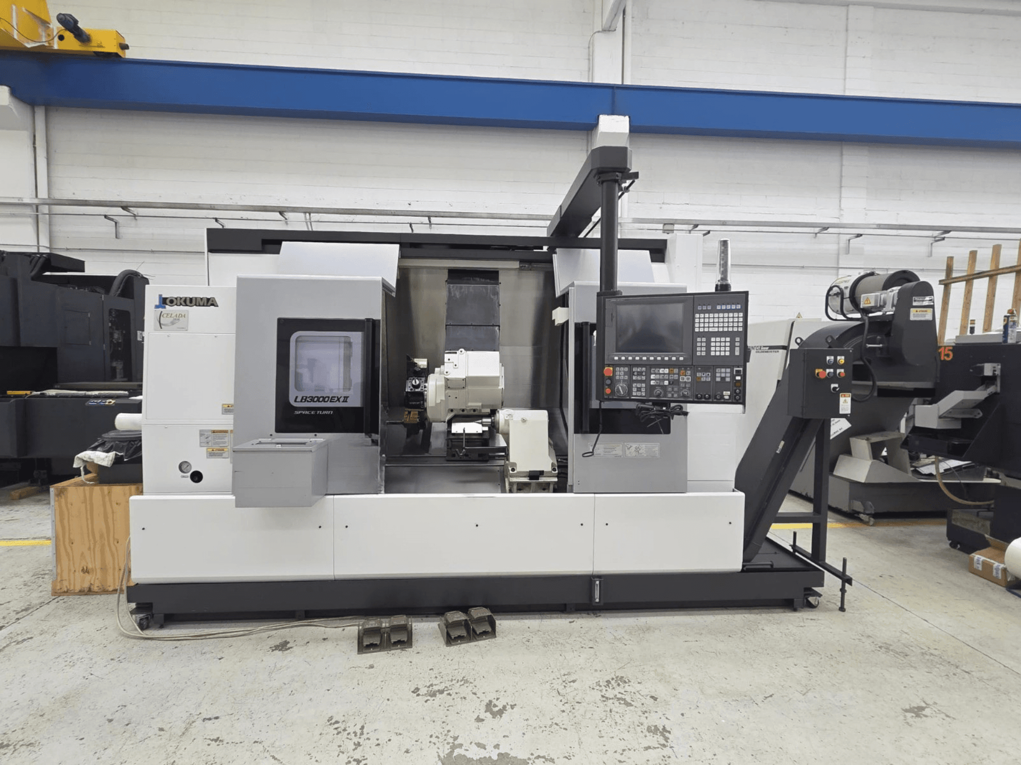 Горизонтальный токарный станок Okuma LB 3000 EXII, вид спереди, панель управления и держатель инструмента.