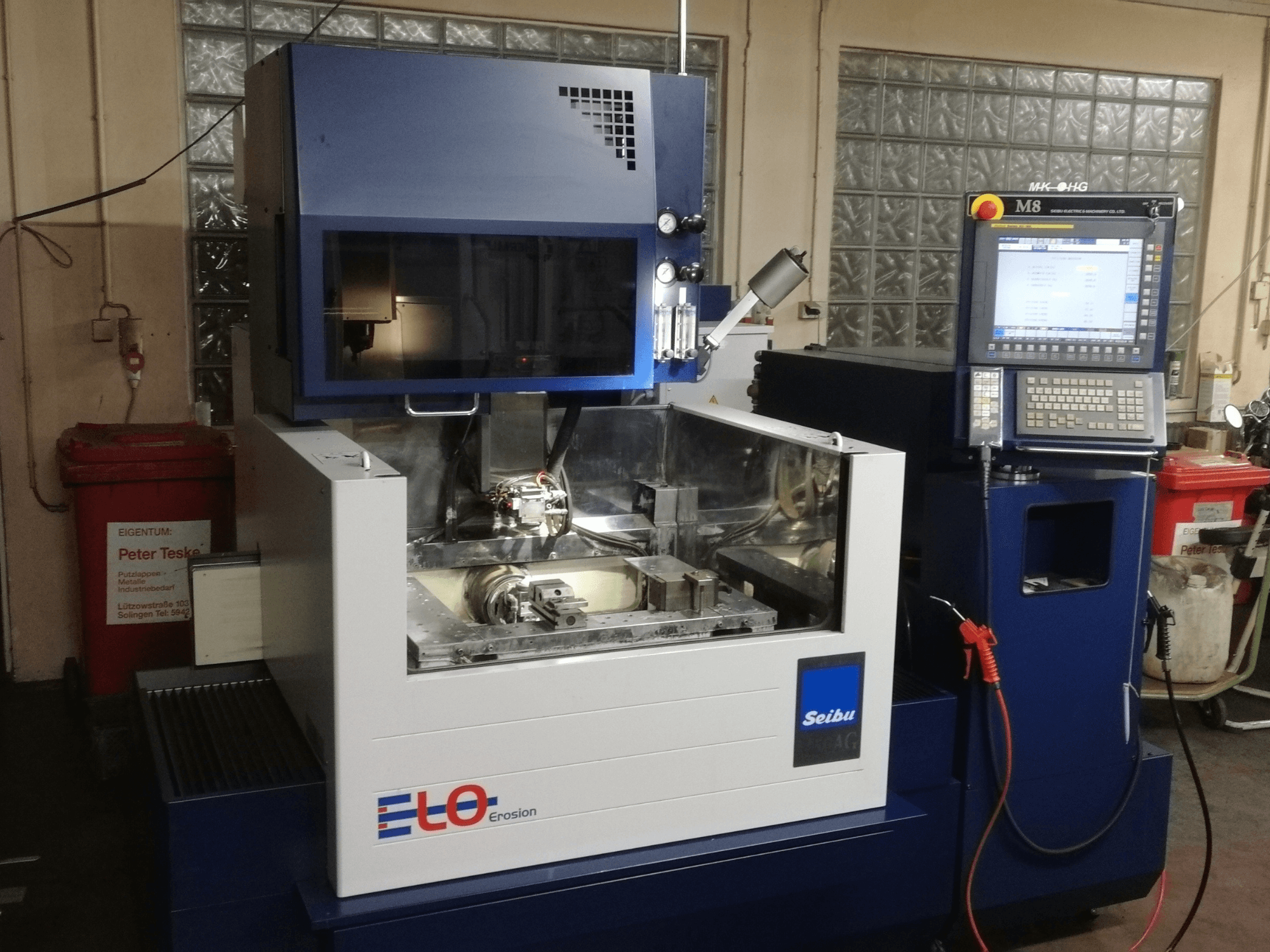 Эрозионная машина ELO Seibu спереди, с панелью управления и видимой рабочей зоной с металлическими компонентами.