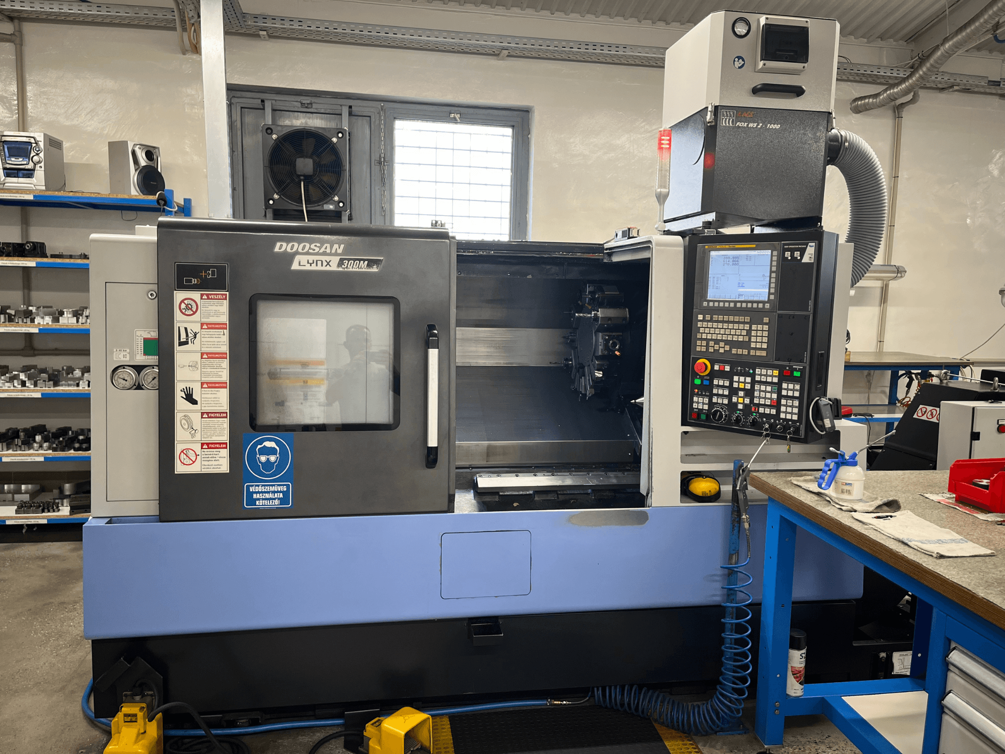 Горизонтальный токарный станок DOOSAN LYNX 300M, вид спереди, с панелью управления и рабочими узлами.